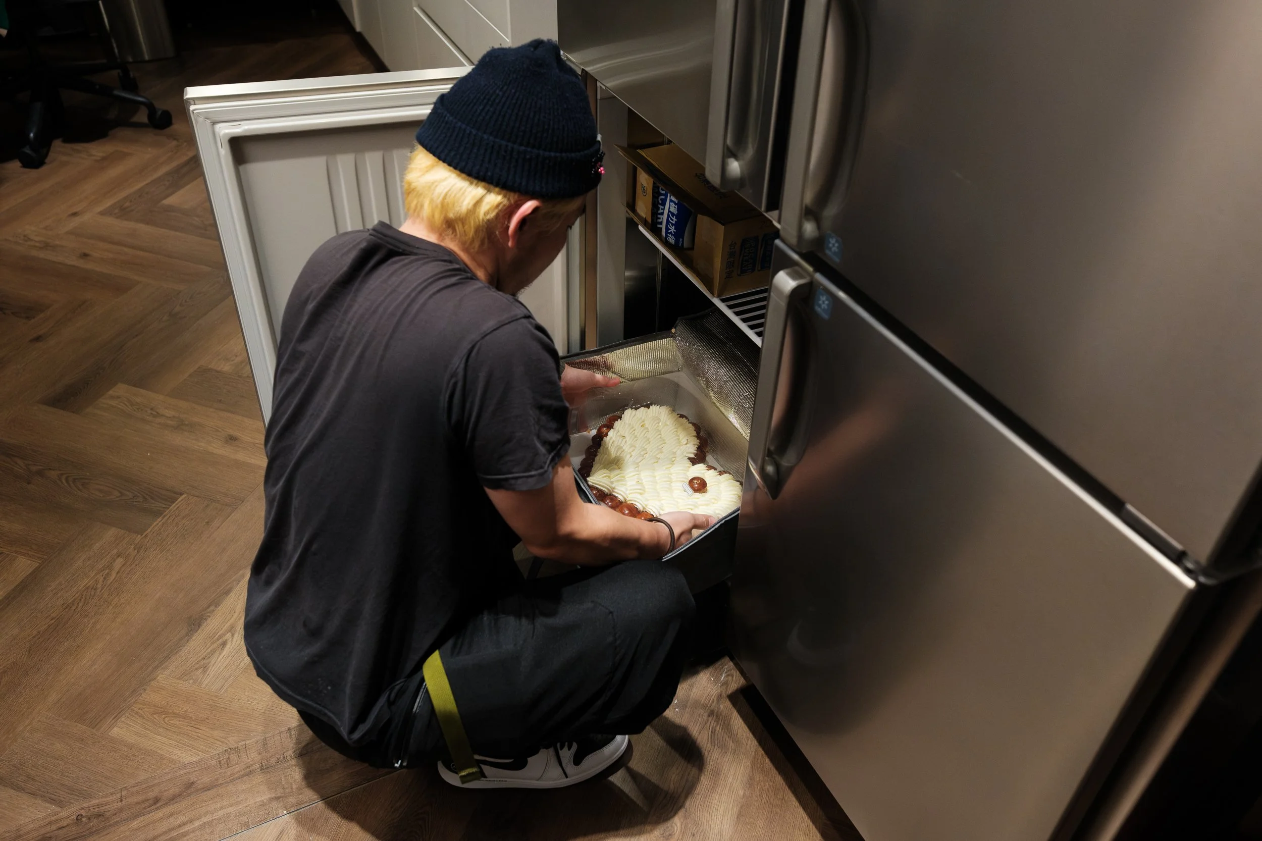 A man is removing a birthday cake from a rifrigerator at MRKT5 in Taipei during his daughter's 9th birthday party.