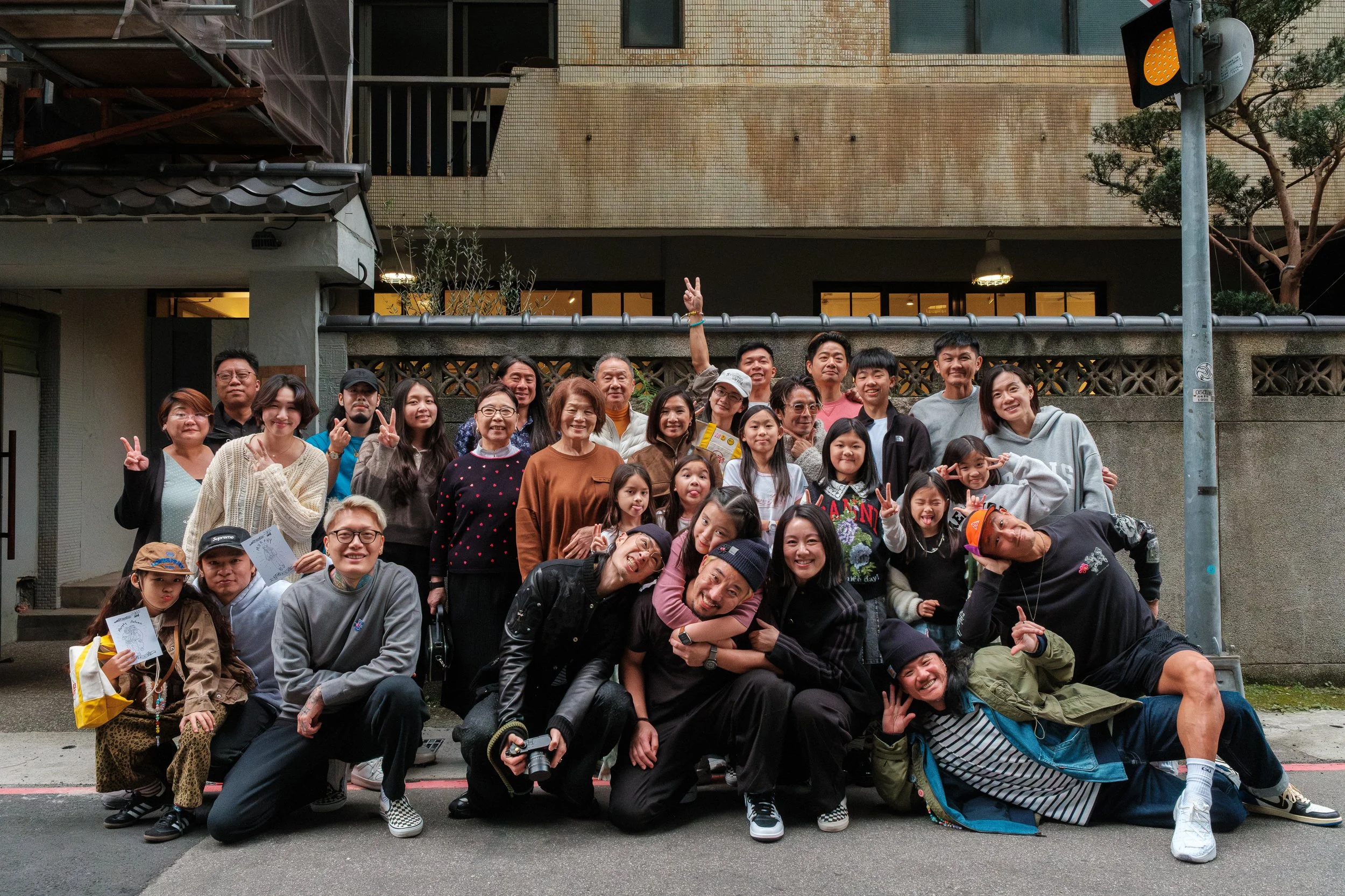 An outdoor group photo of the guests at a little girl's 9th birthday party in Taipei. Vanness Wu is in the front row. 