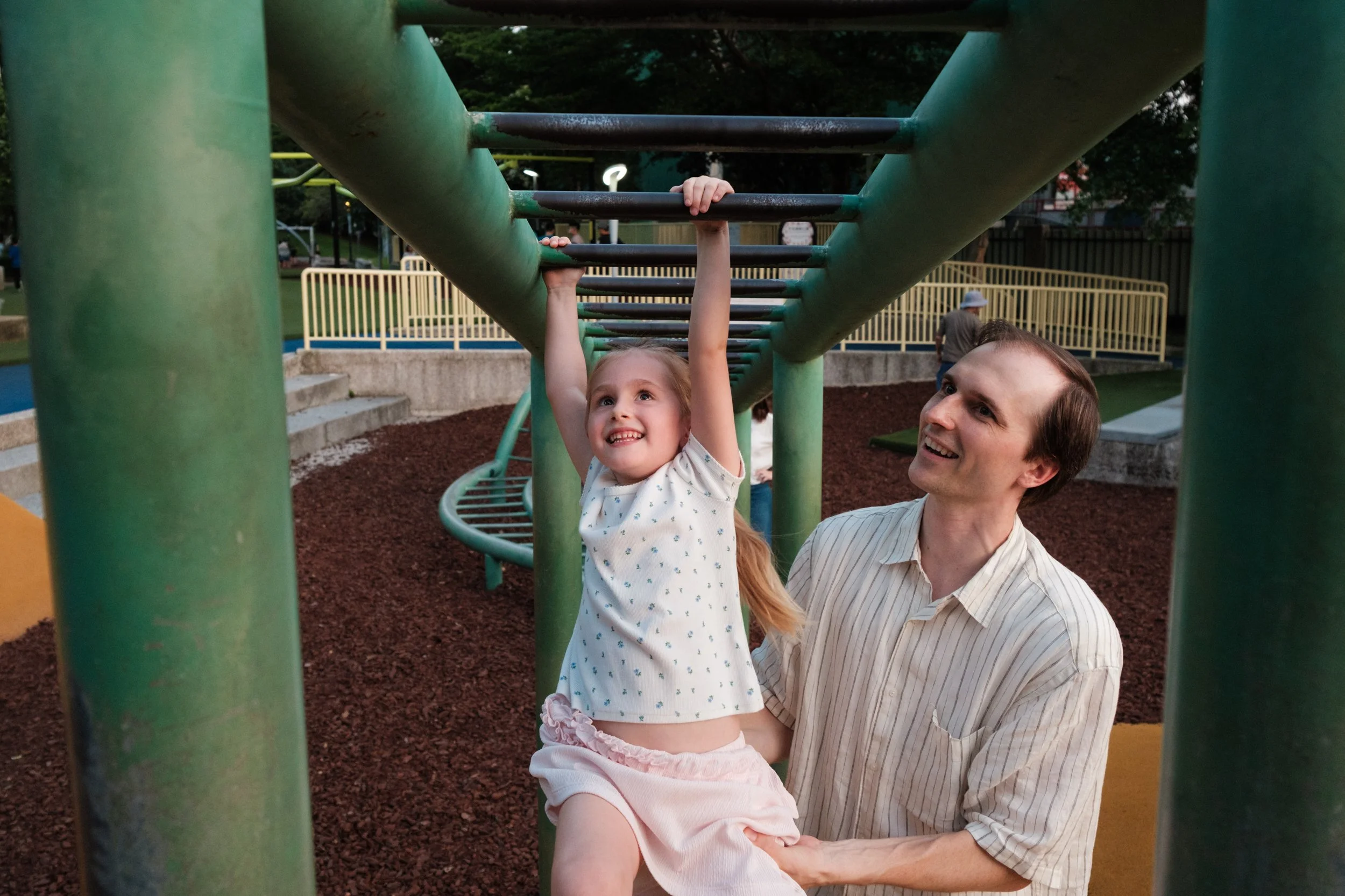 Taipei documentary family photography, Tienmu Sports Park | Father lifts his daughter on the monkey bars at the playground