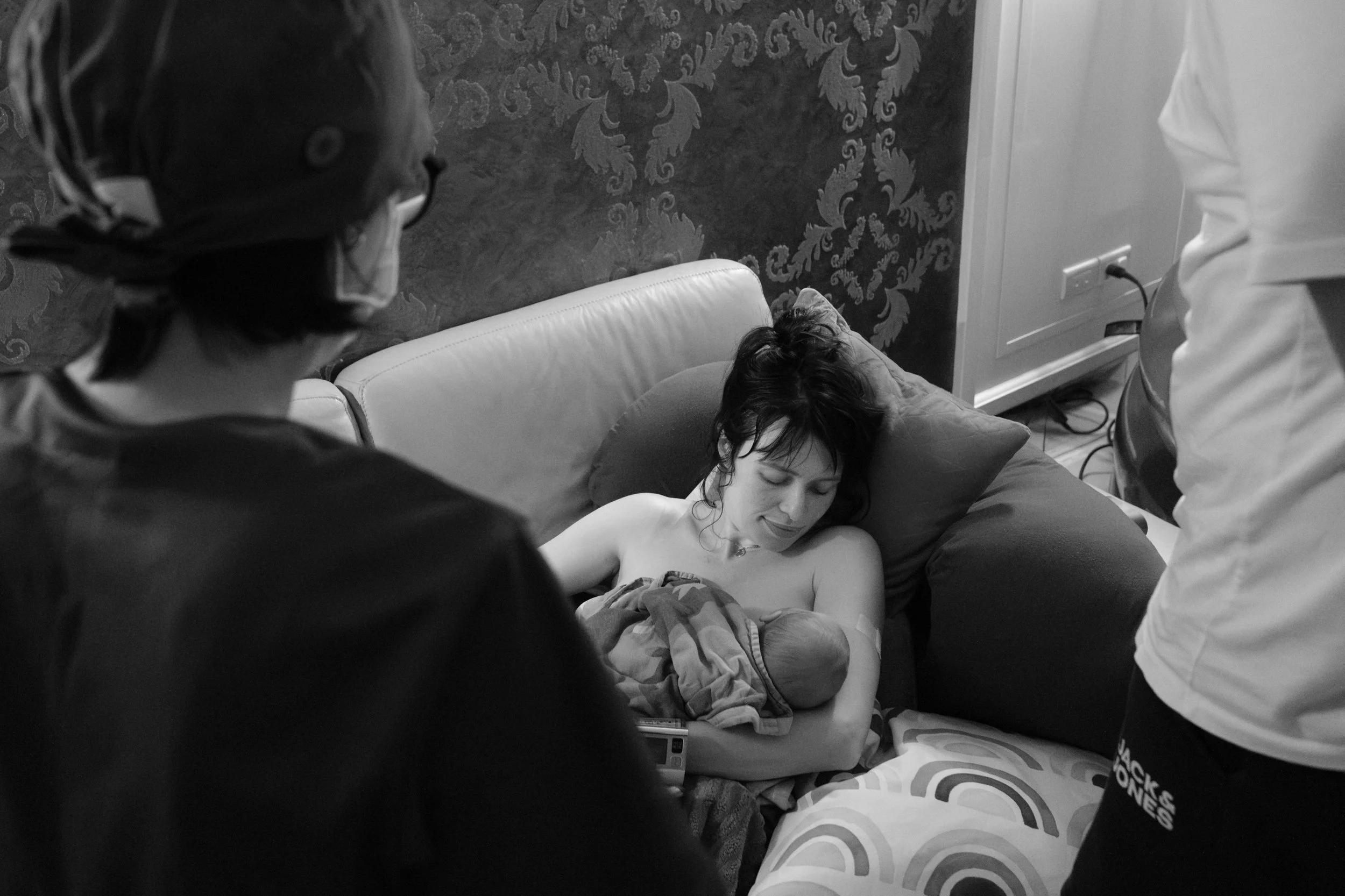 Mother breastfeeding her newborn on the couch shortly after a home birth in Taipei