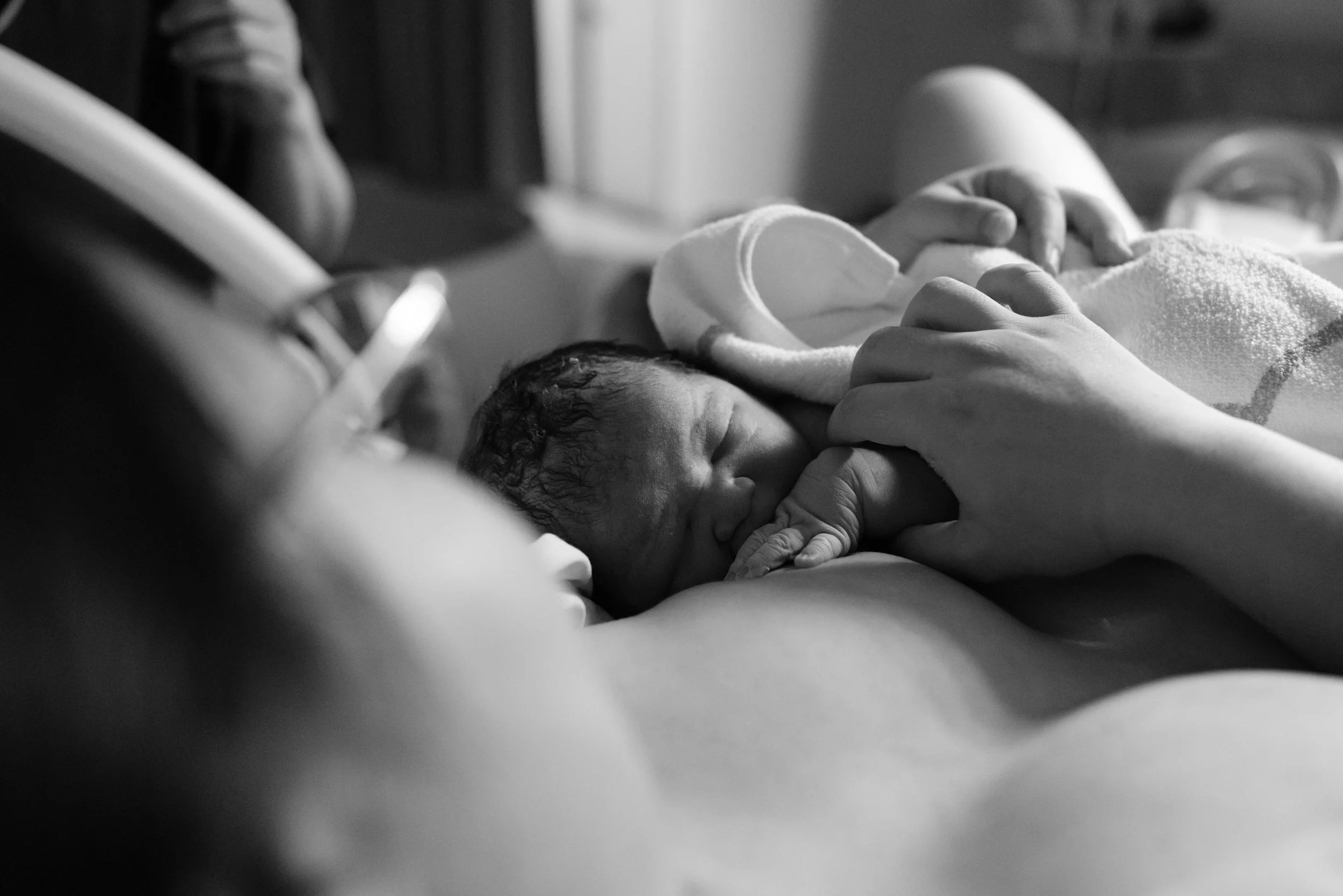 Close-up newborn portrait from a Dianthus, Taipei birth photography session, baby resting against mother's chest.