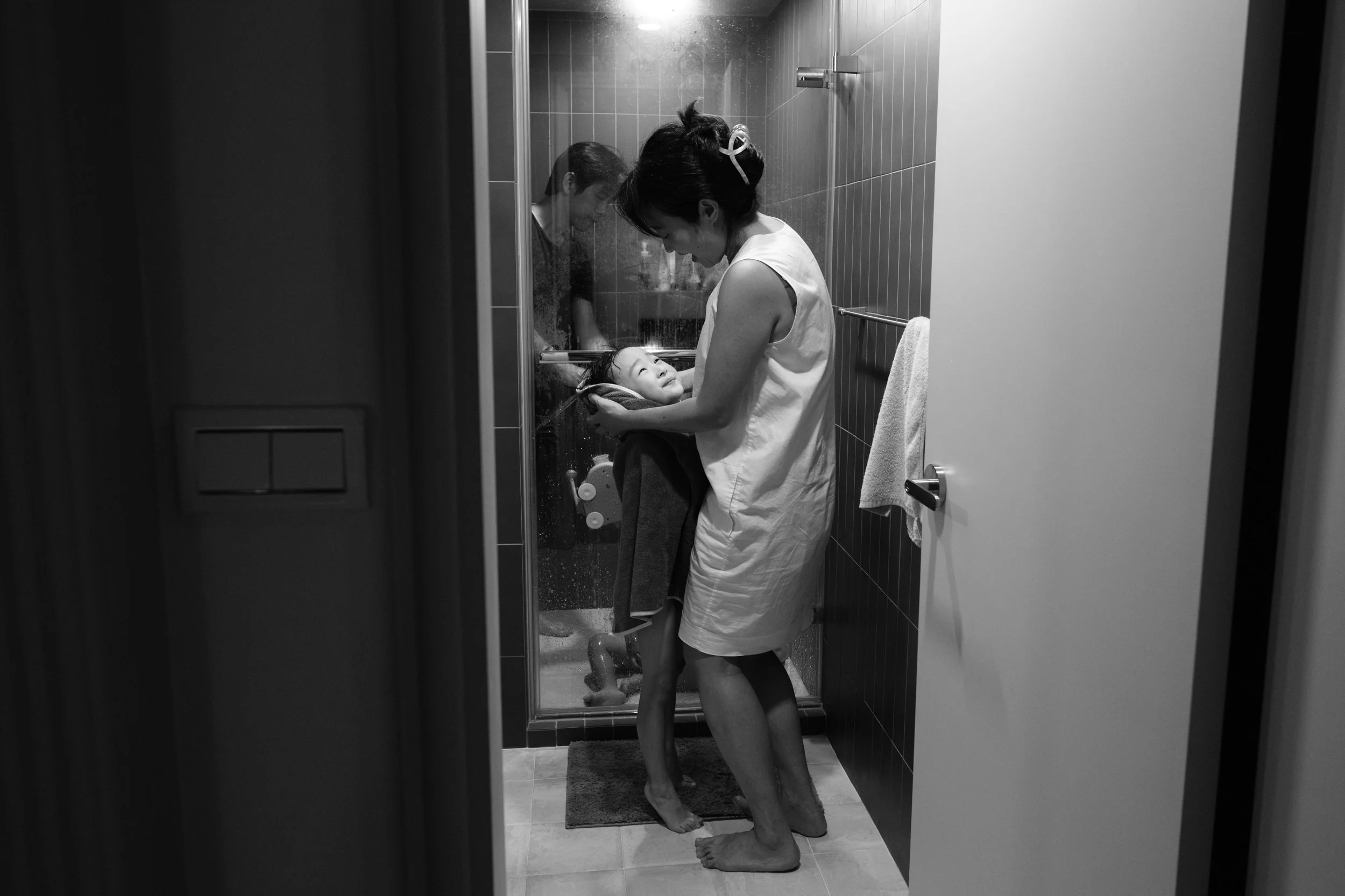 Taipei documentary family photographer image of a mother wrapping her son in a towel after the bath, part of an in-home bedtime session.