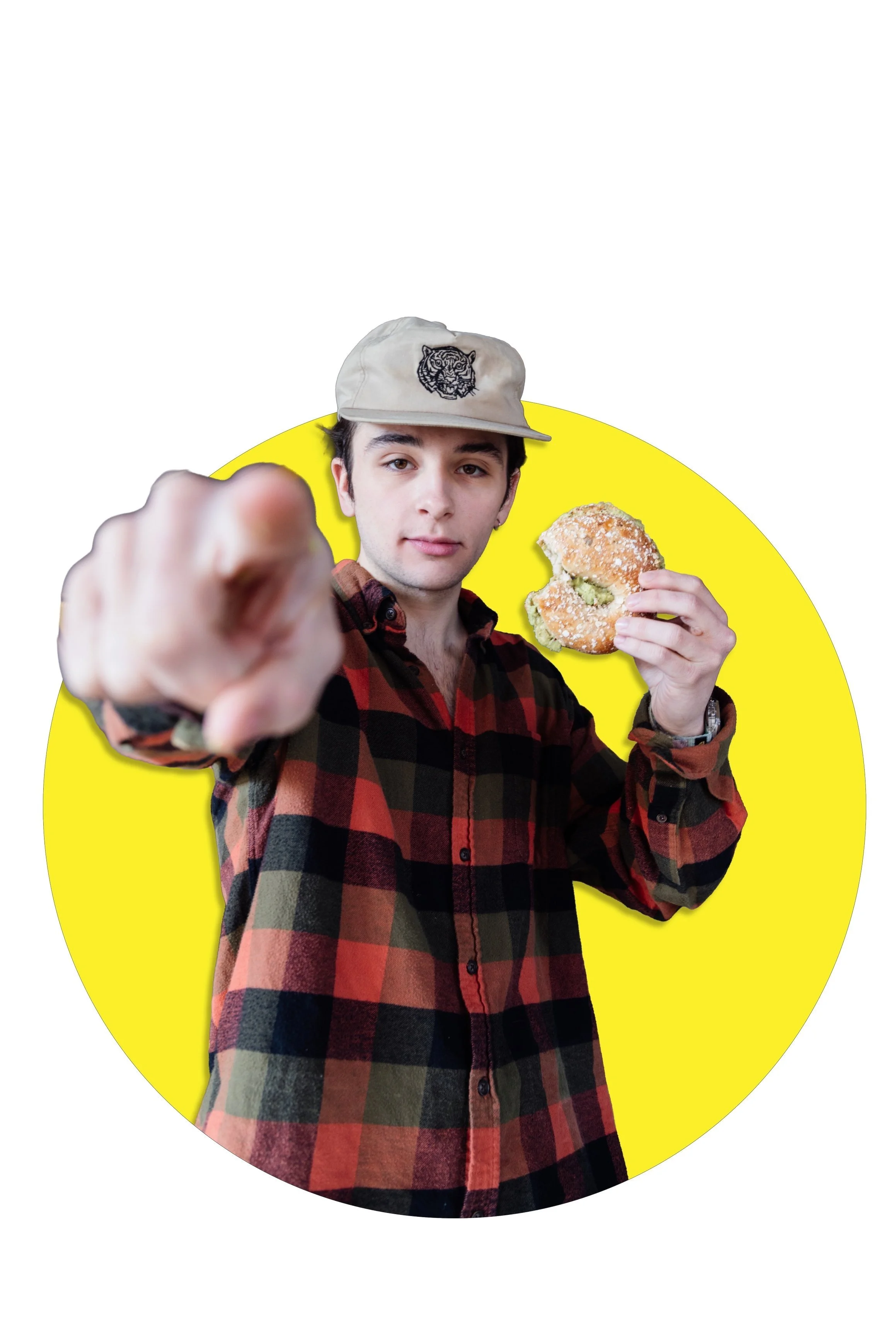 Barista Chris, holding a bagel sandwich and pointing at the camera
