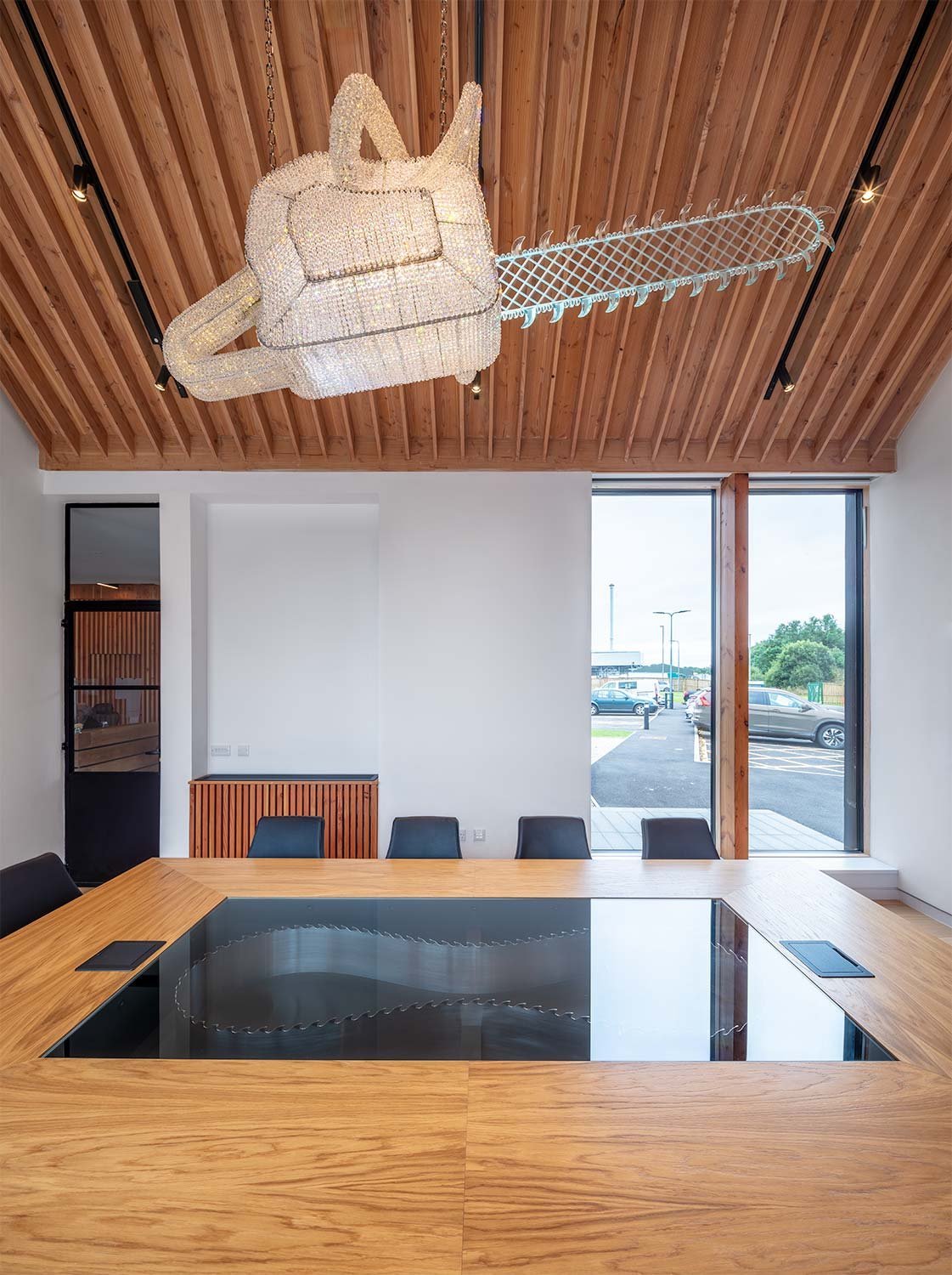 bespoke meeting room table with crystal glass chainsaw sculpture