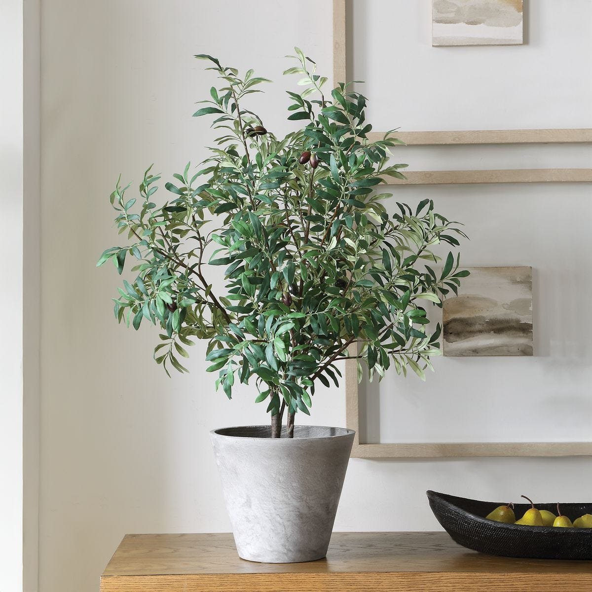 Artificial olive tree potted in a smooth stone gray ceramic planter