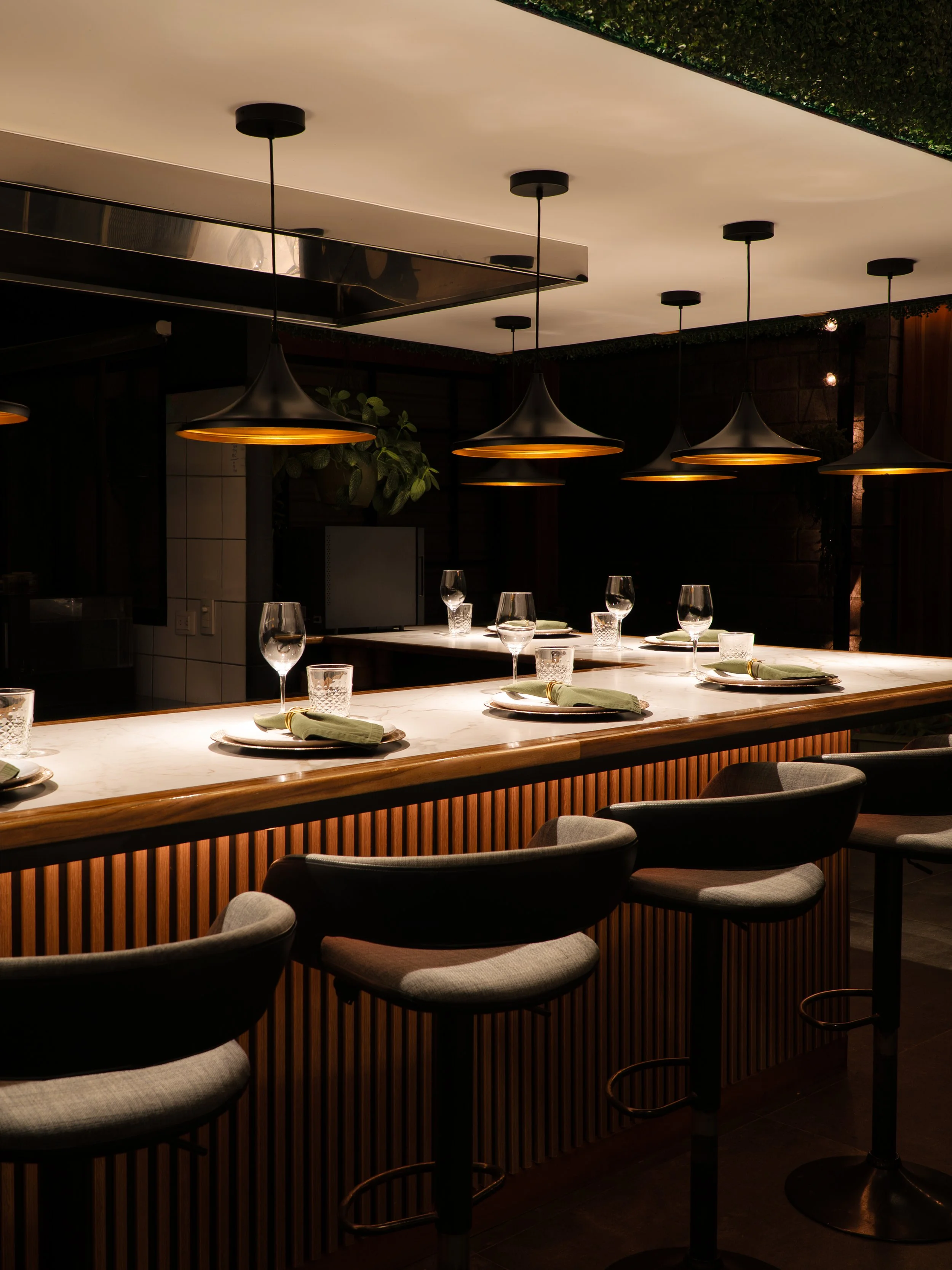 Chef's counter at El Taller de Billy Sazón in San José, with high stools facing the kitchen
