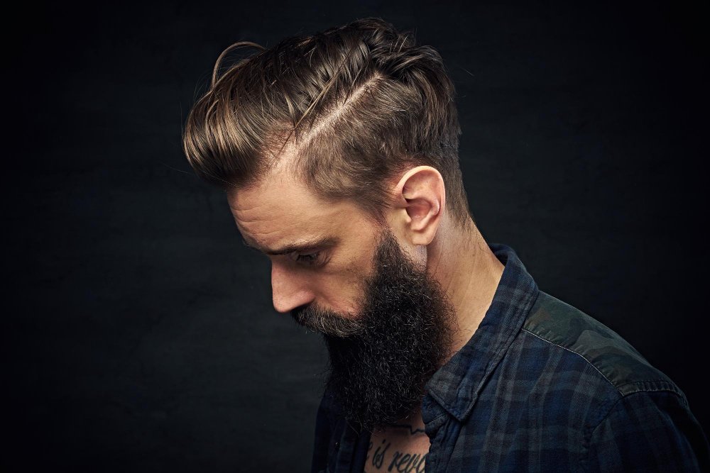 side-part-close-up-portrait-bearded-male-with-long-hair-dark-background.jpeg