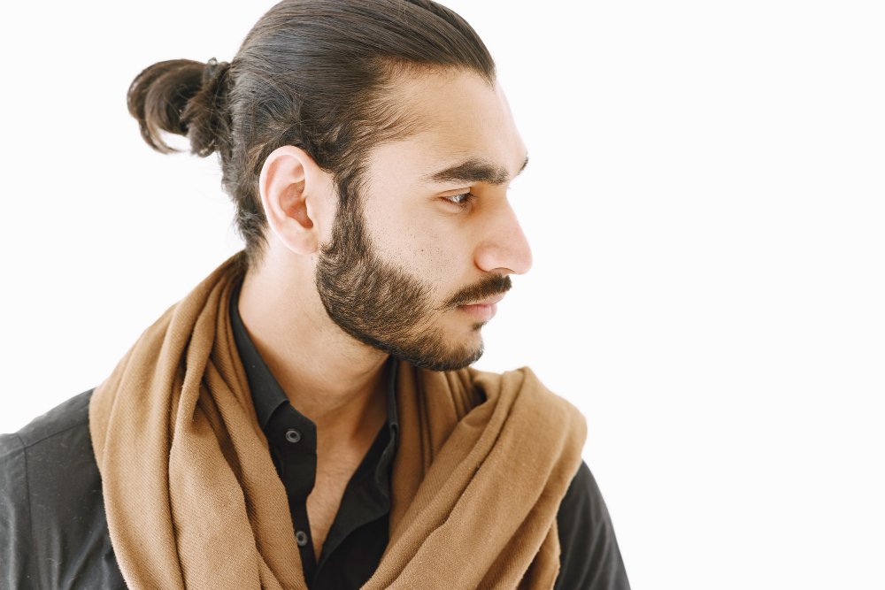 man-bun-young-man-posing-casually-white-wall-studio-isolated.jpeg