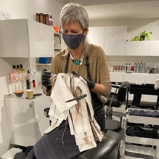 JamieB, hair stylist, wearing a mask while working in her San Francisco salon.