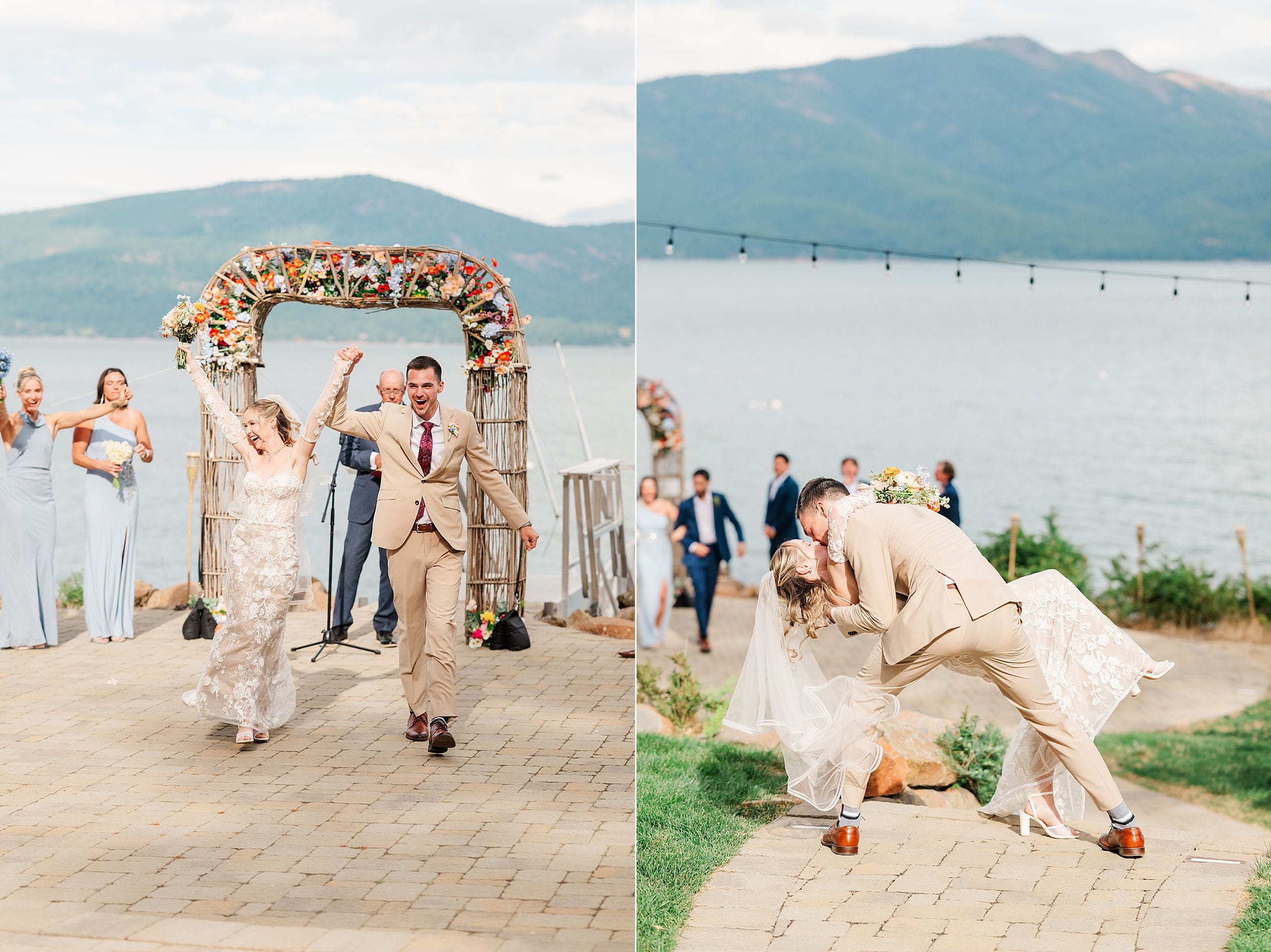 Newlyweds celebrate by a lakeside mountain venue: the bride raises her arms beneath a flower-covered arch, then kisses the groom joyfully.