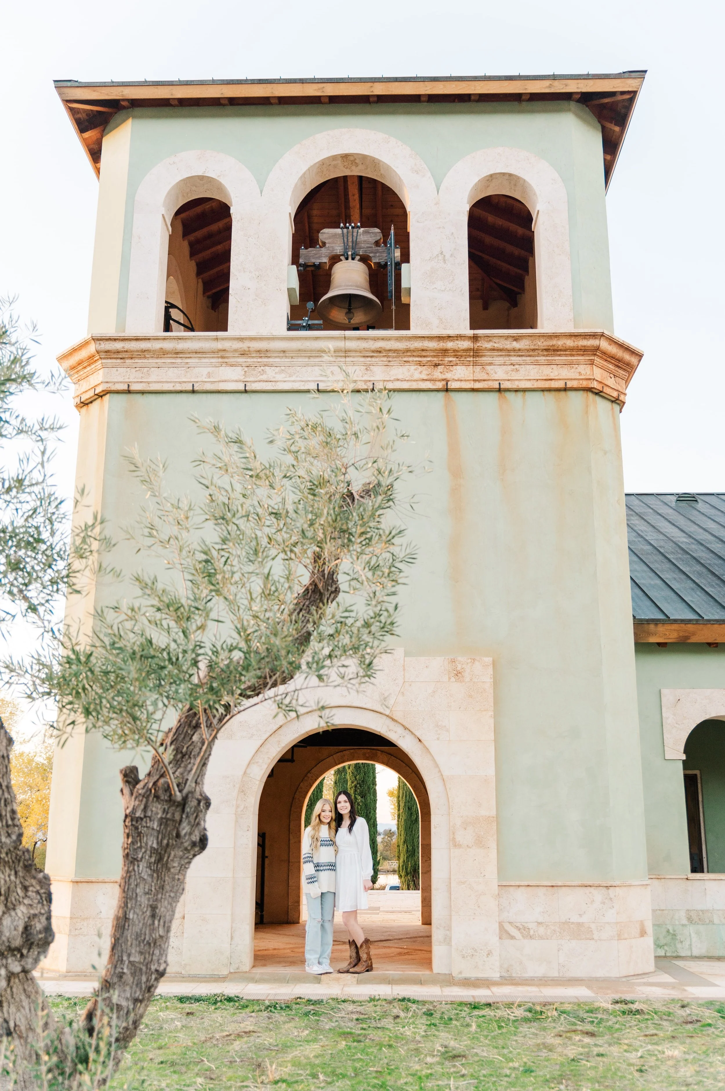 twin sisters in front of bell tower at anselmo vineyards chapel