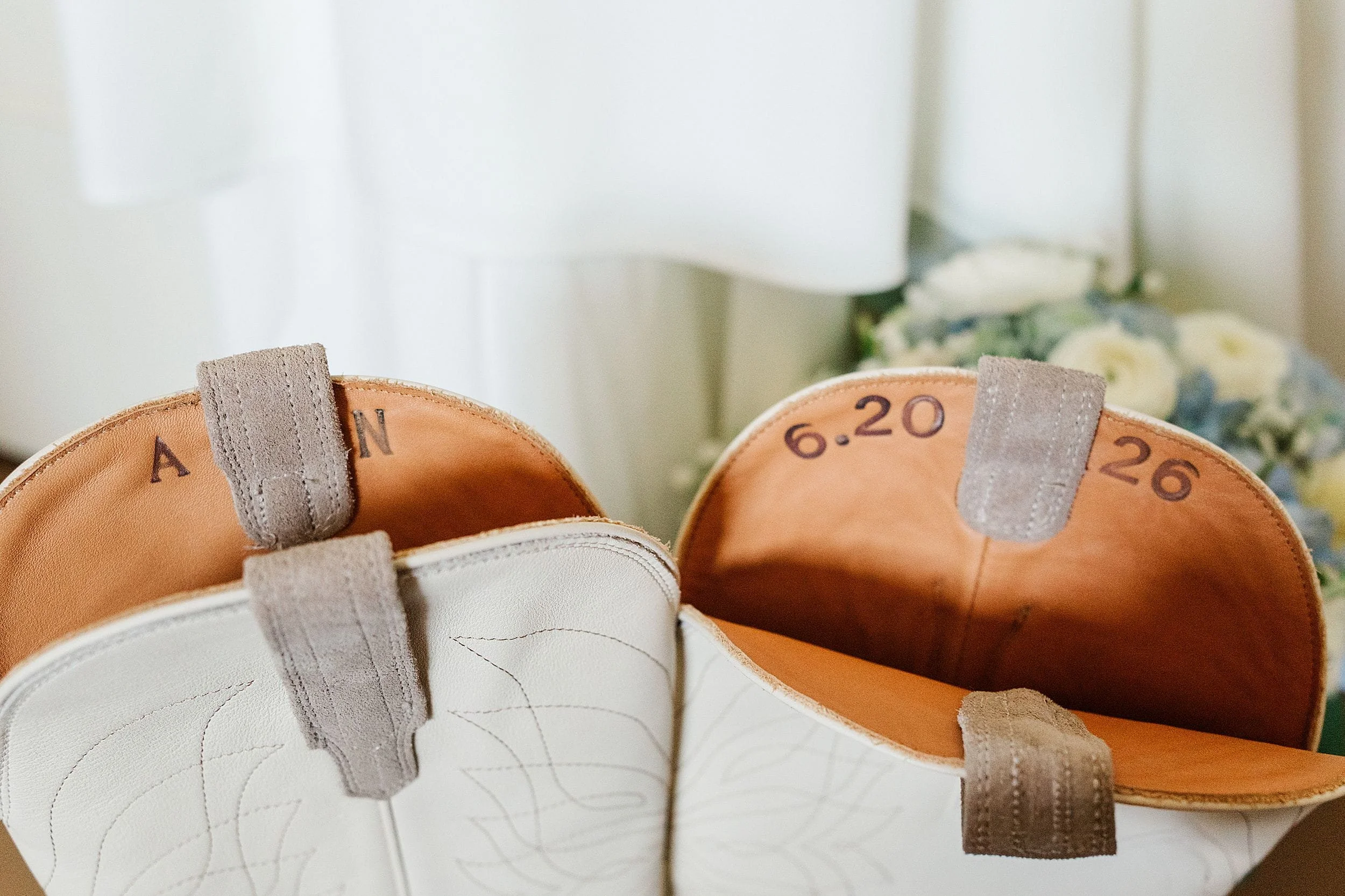 Personalized white bridal boots with the couple’s wedding date inside.