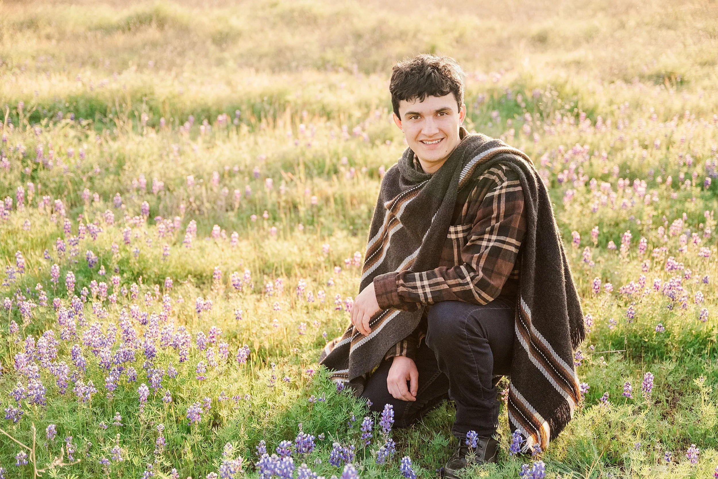 high school senior guy in field of wildflowers