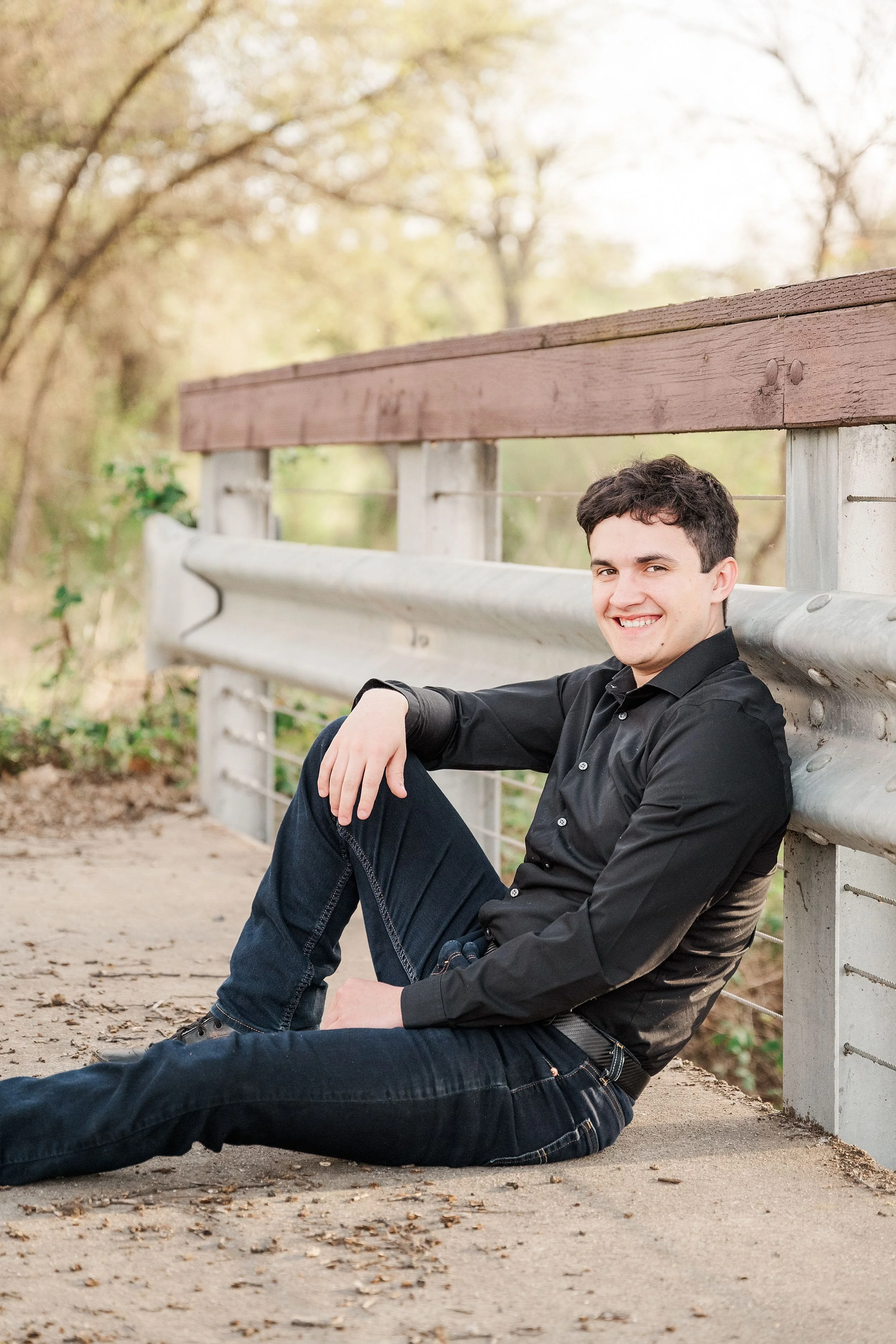 teenage boy sitting on bridge