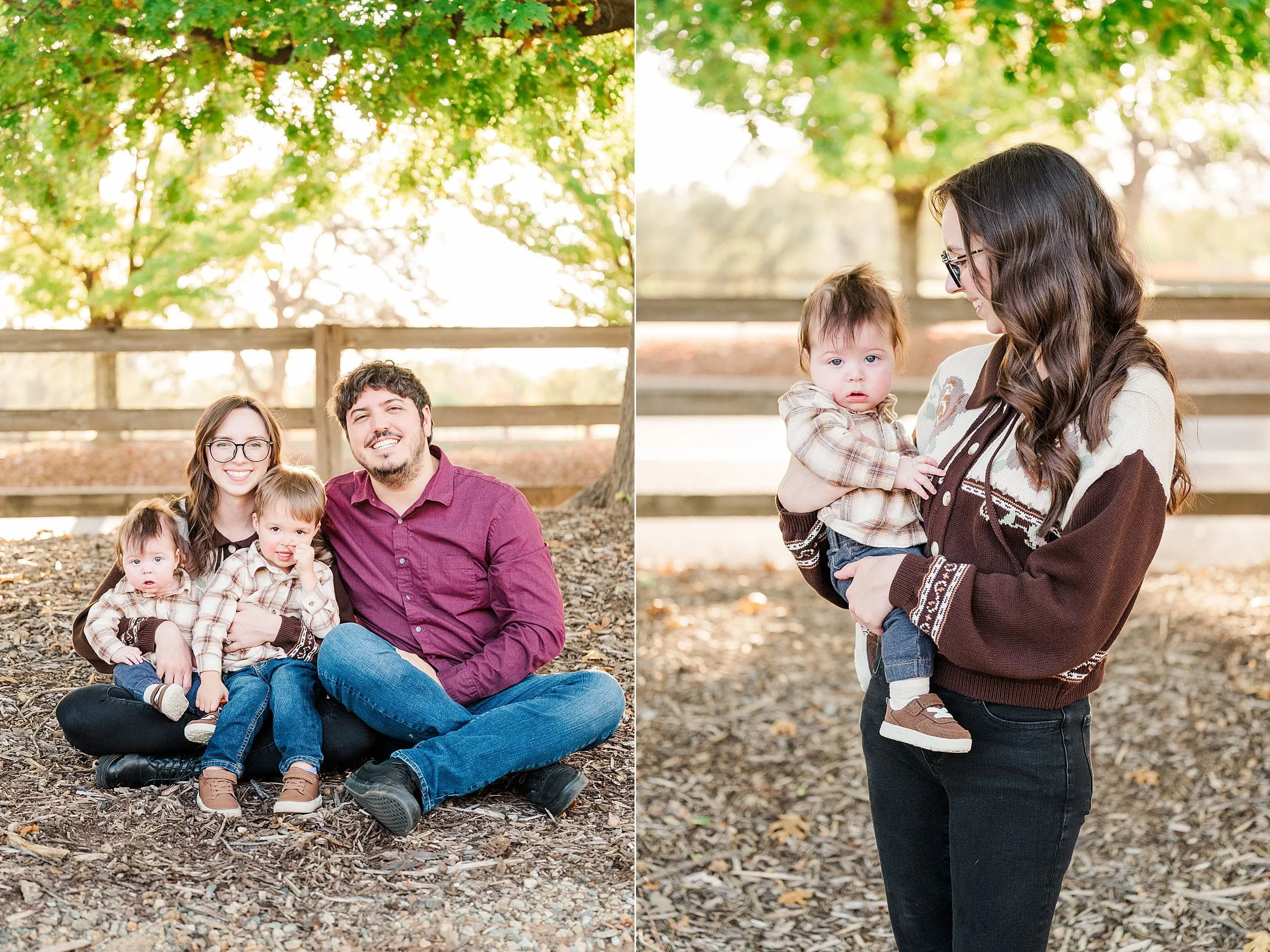 Outdoor family portrait: parents sit with two young children beneath autumn trees, while the mother holds a toddler nearby. Warm light and relaxed smiles create a cozy, affectionate mood.