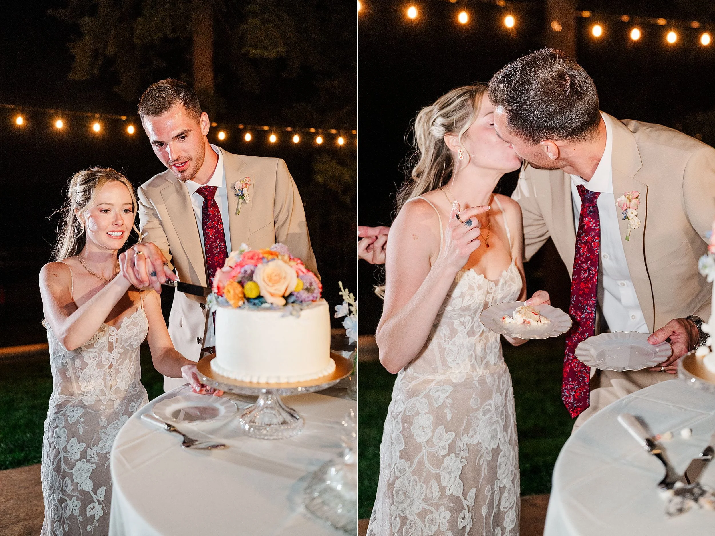 Newlywed couple cuts a flower-topped wedding cake, then shares a tender kiss beside a decorated reception table under glowing string lights.