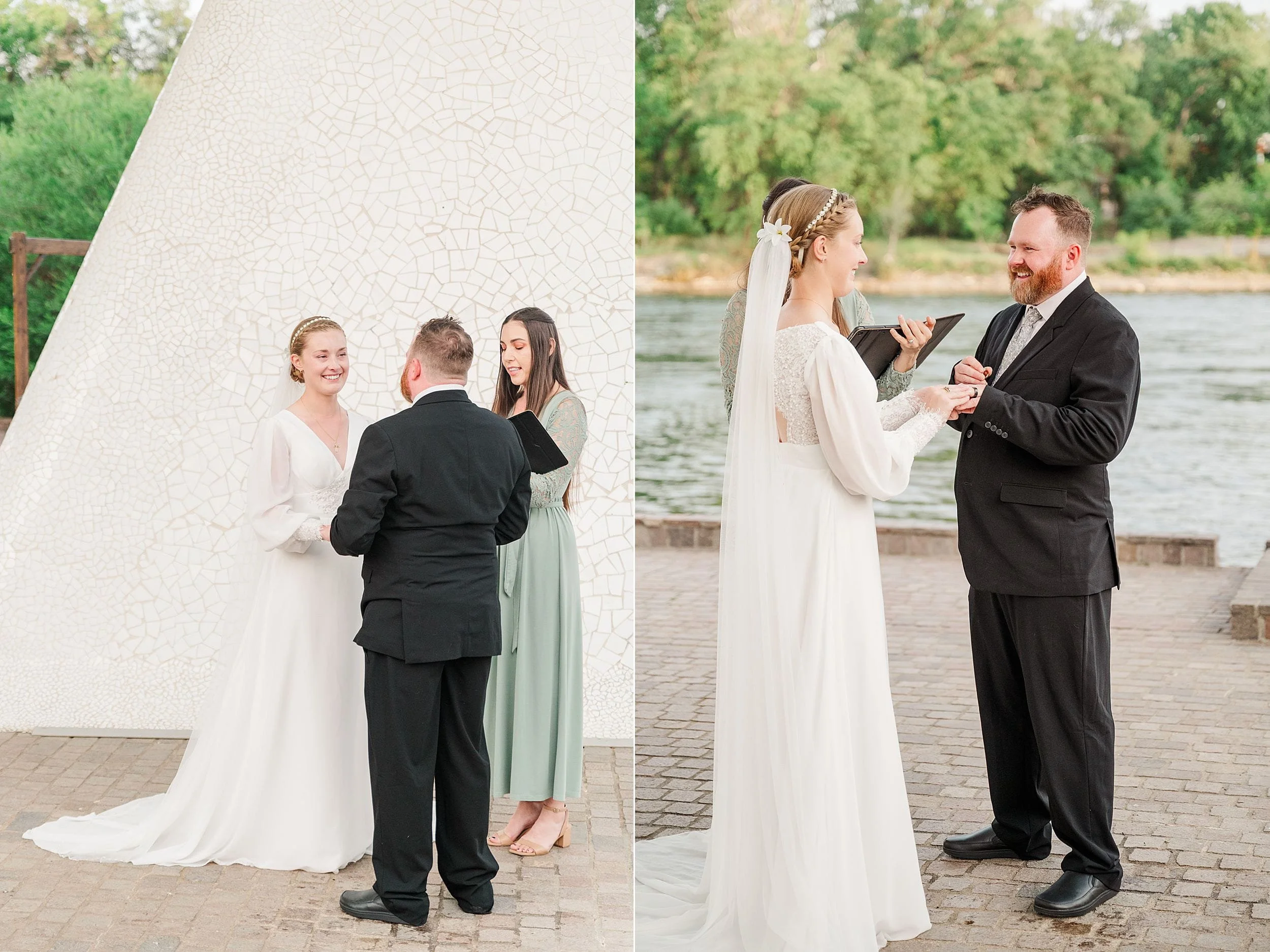 A couple exchanges vows in an outdoor wedding. The bride, in a flowing white dress, and groom, in a black suit, smile warmly. A serene river is in the background.