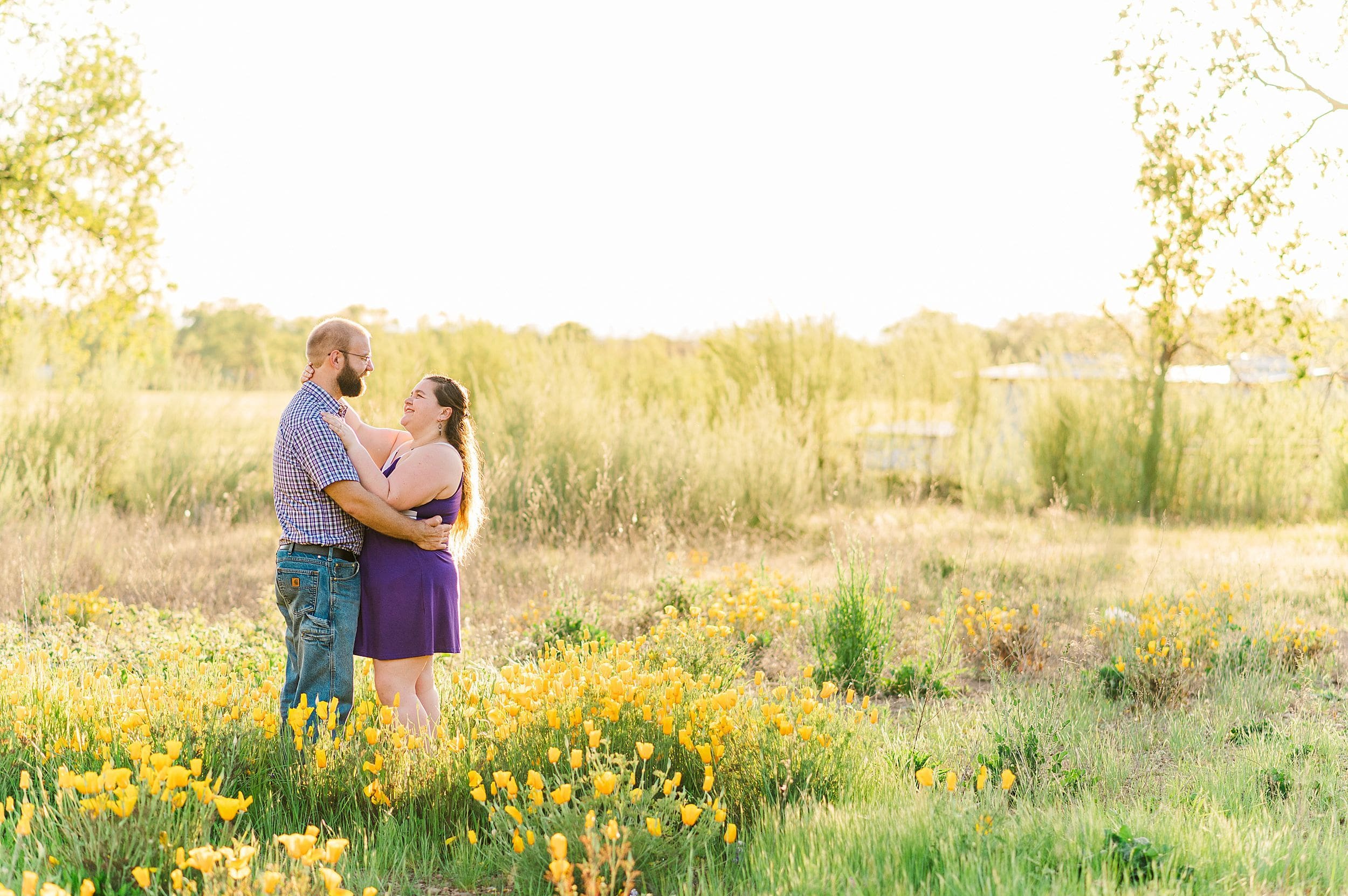 couple at their spring engagement session in a wild poppy field