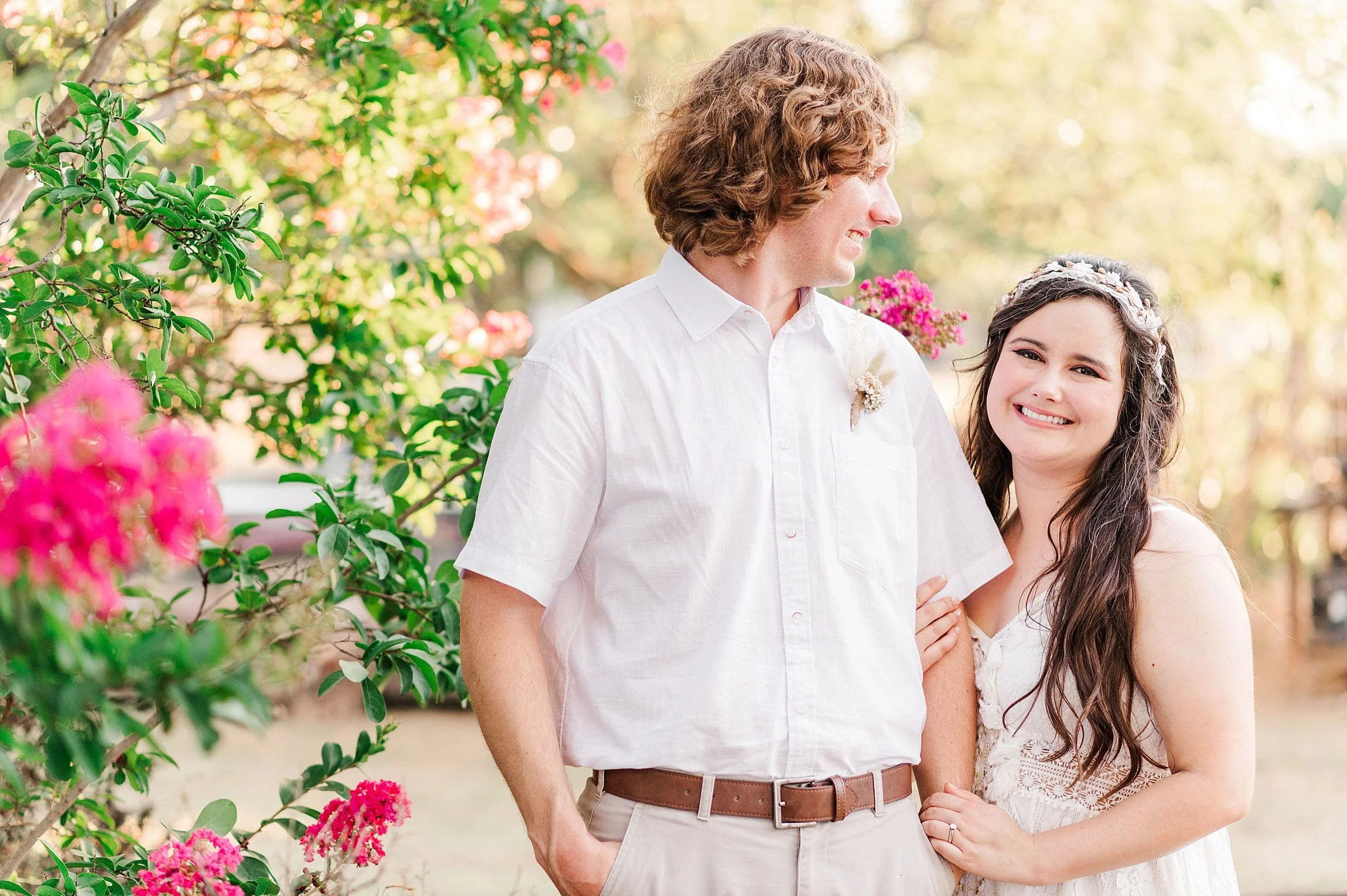 man smiling down at his beautiful fiance wearing white lace boho dress