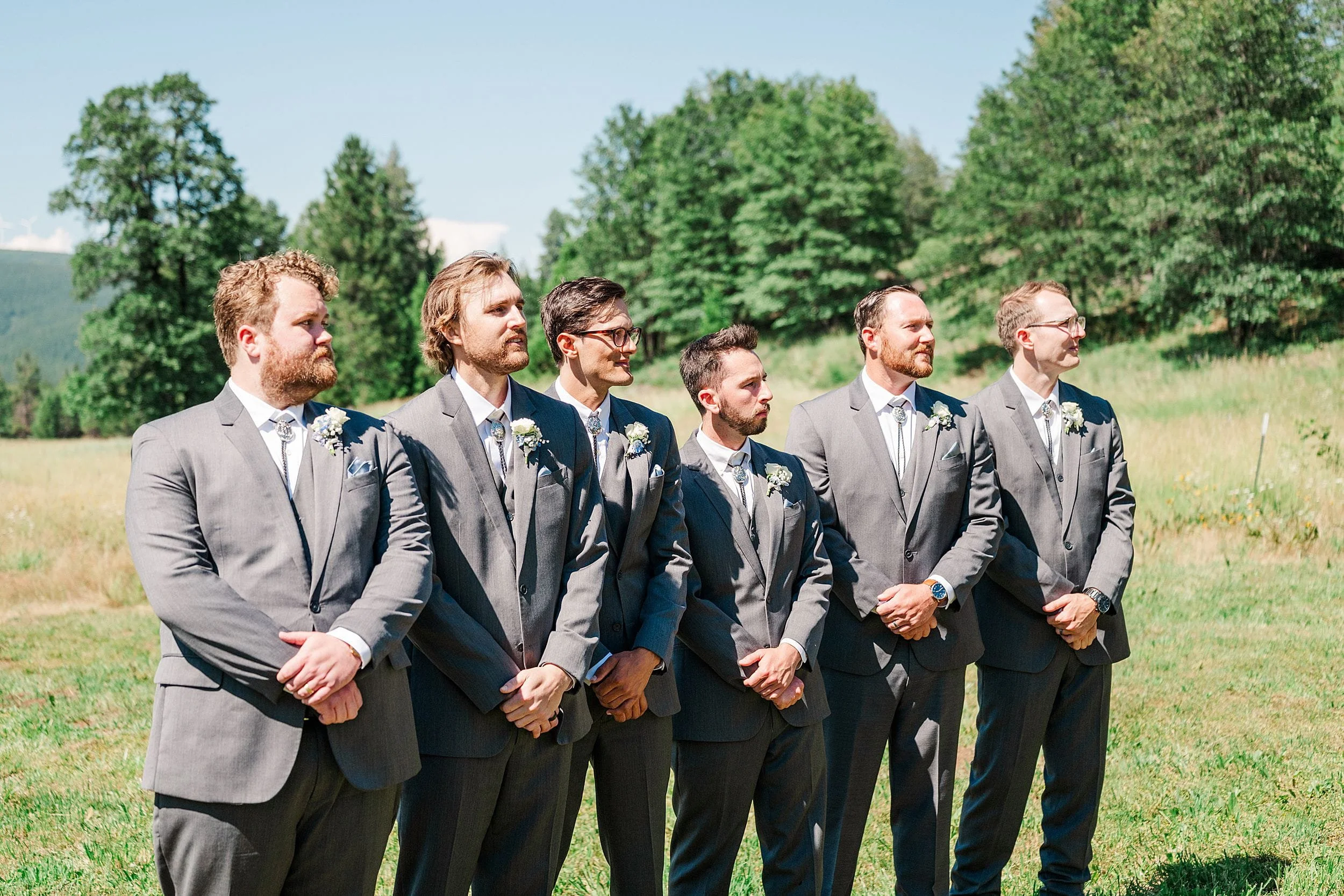 Groomsmen watching bridesmaid walk down aisle during wedding ceremony.