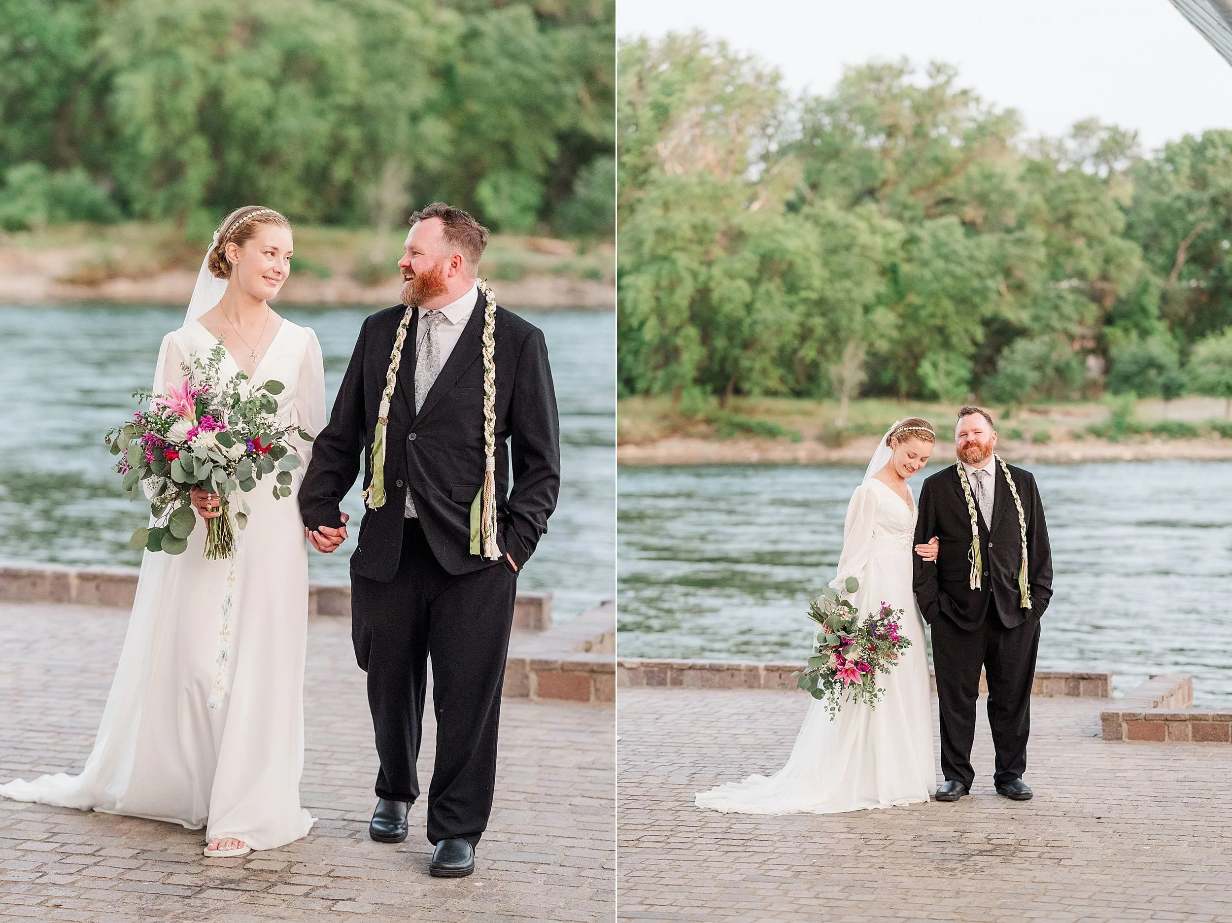 A bride and groom stand by a river, smiling warmly. The bride holds a vibrant bouquet and wears a flowing white dress, while the groom dons a dark suit. The serene setting with lush greenery creates an intimate, joyful atmosphere.