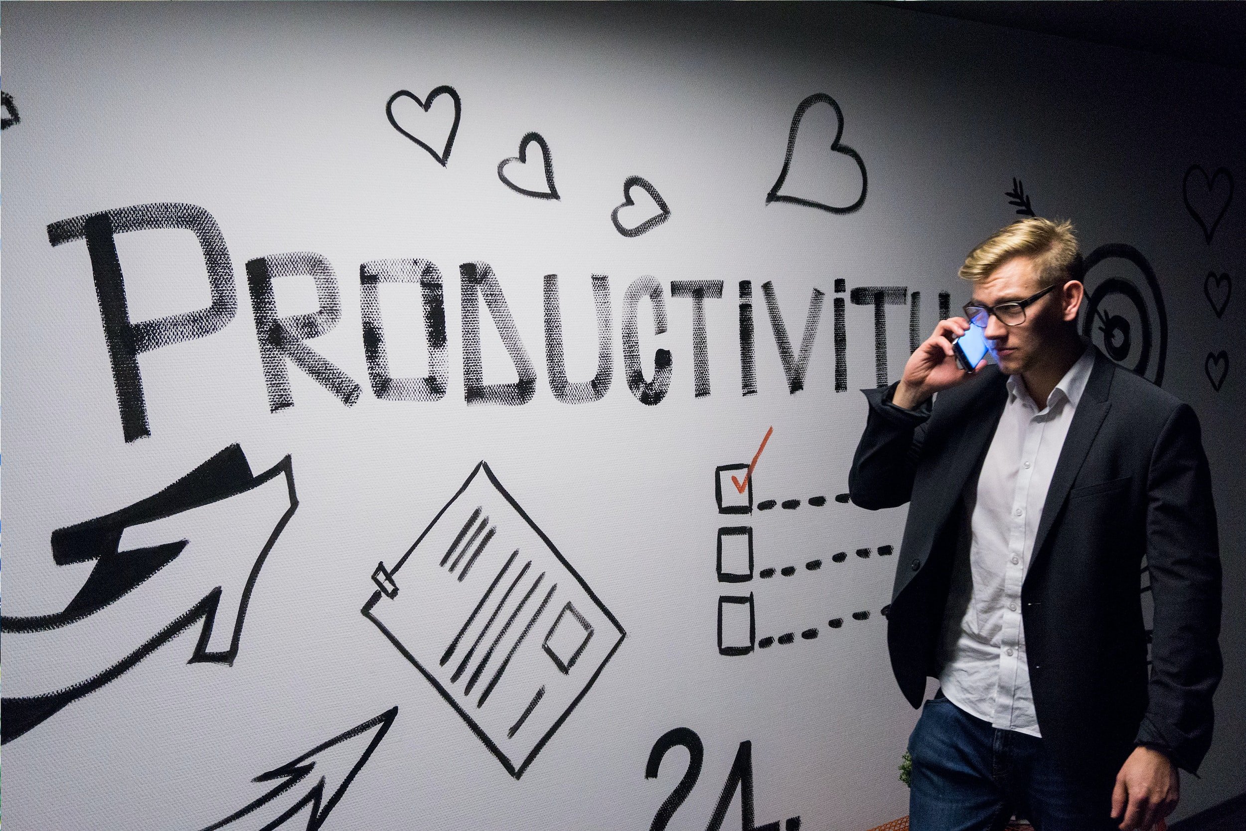 a person on the phone walking by a wall the says productivity