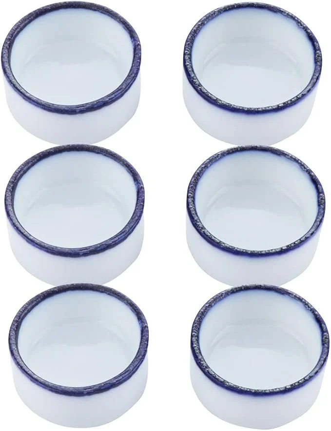 Six white ceramic cups with blue decorative rims, arranged in two columns of three.