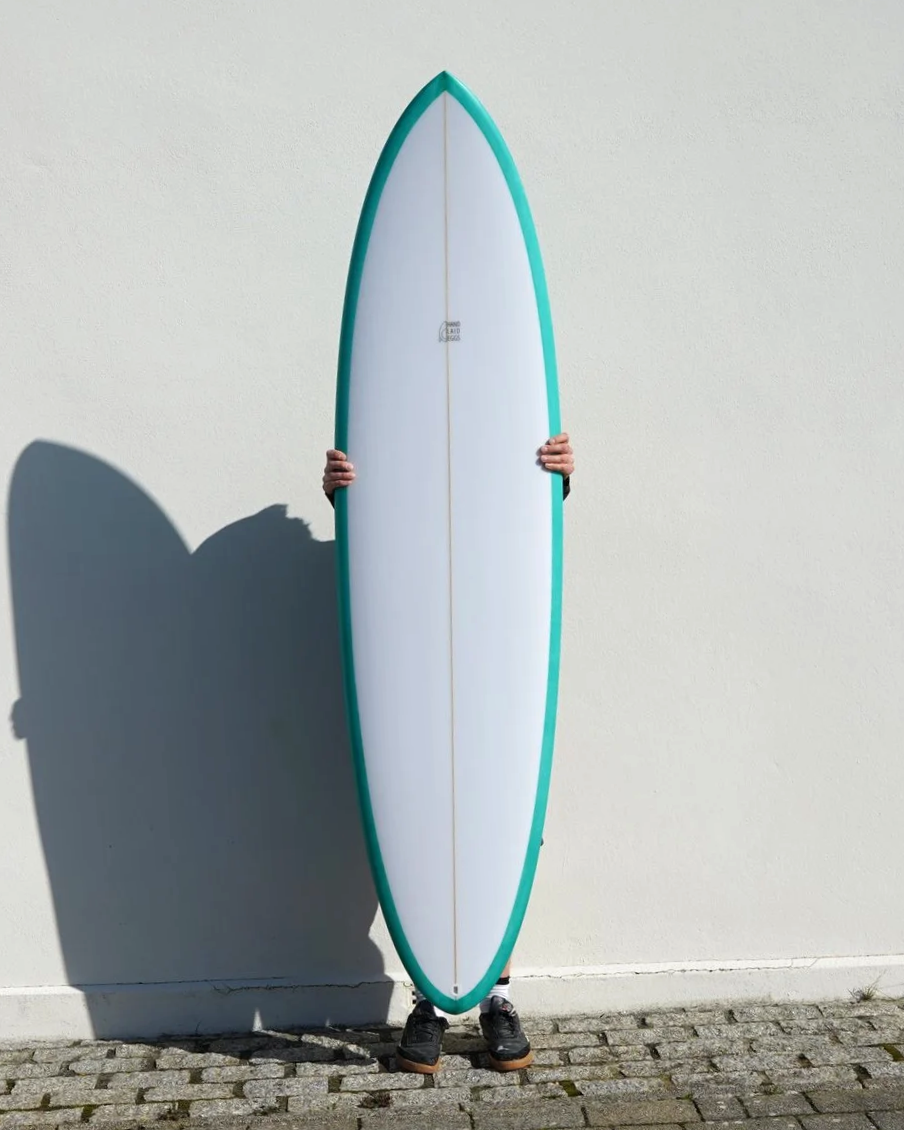 Mid length surfboard white deck with green rails