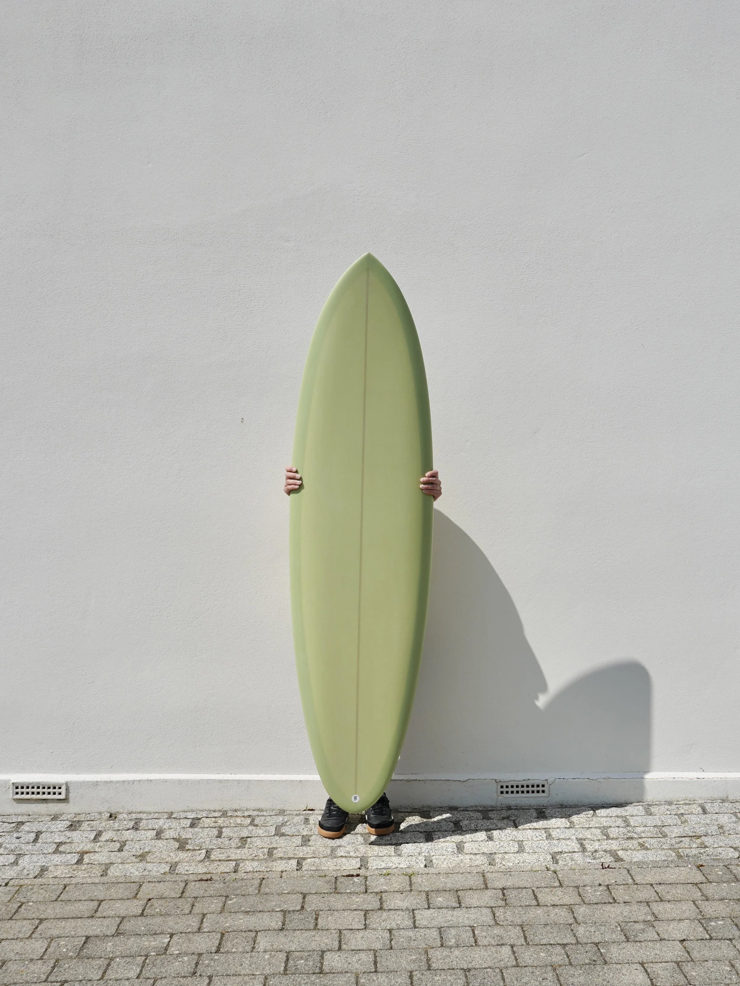 Green custom mid length surfboard