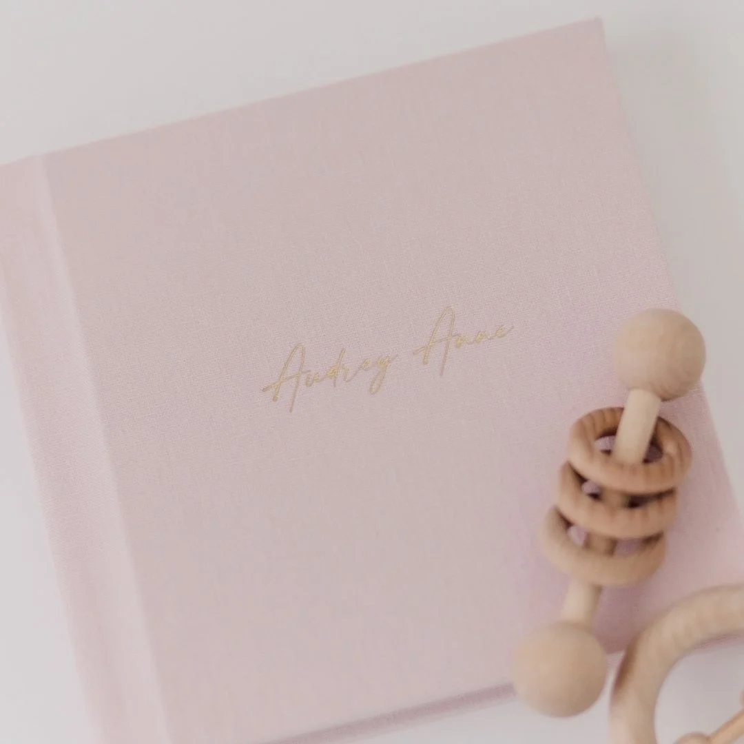 Newborn. Sitter. One year.
Three sessions. One album. A whole lifetime to look back on it.
Audrey Anne&rsquo;s first year is officially documented &mdash; linen cover, gold foil name, and every single one of my favorite things about watching her grow