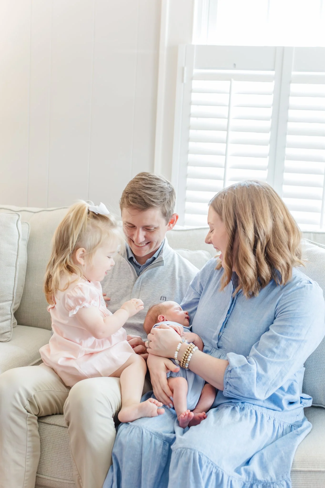 family piled on the couch at in home lifestyle newborn session in greenville south carolina