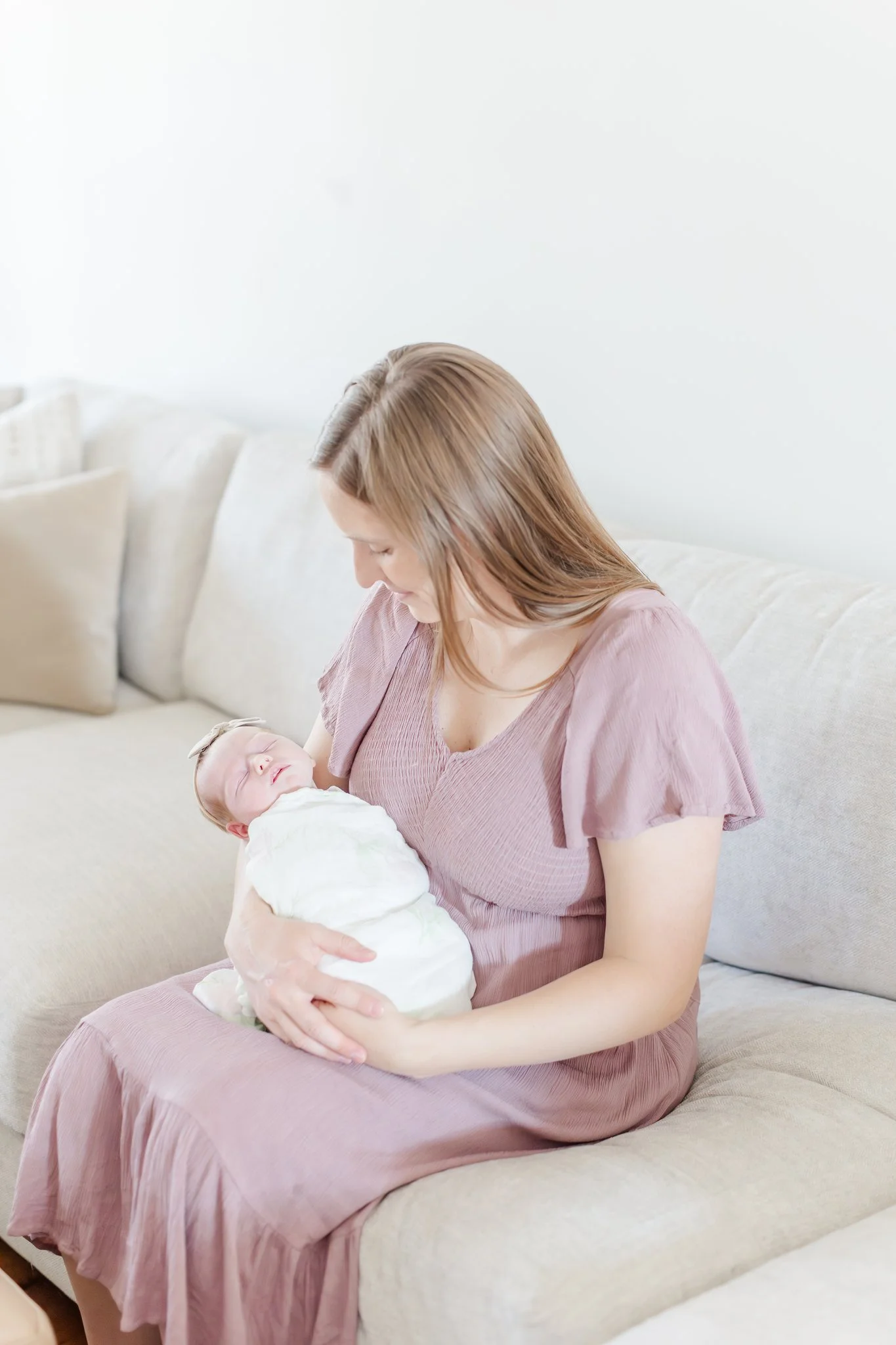 Newborn baby Eloise held by mom in mauve dress, Powdersville SC in-home newborn session