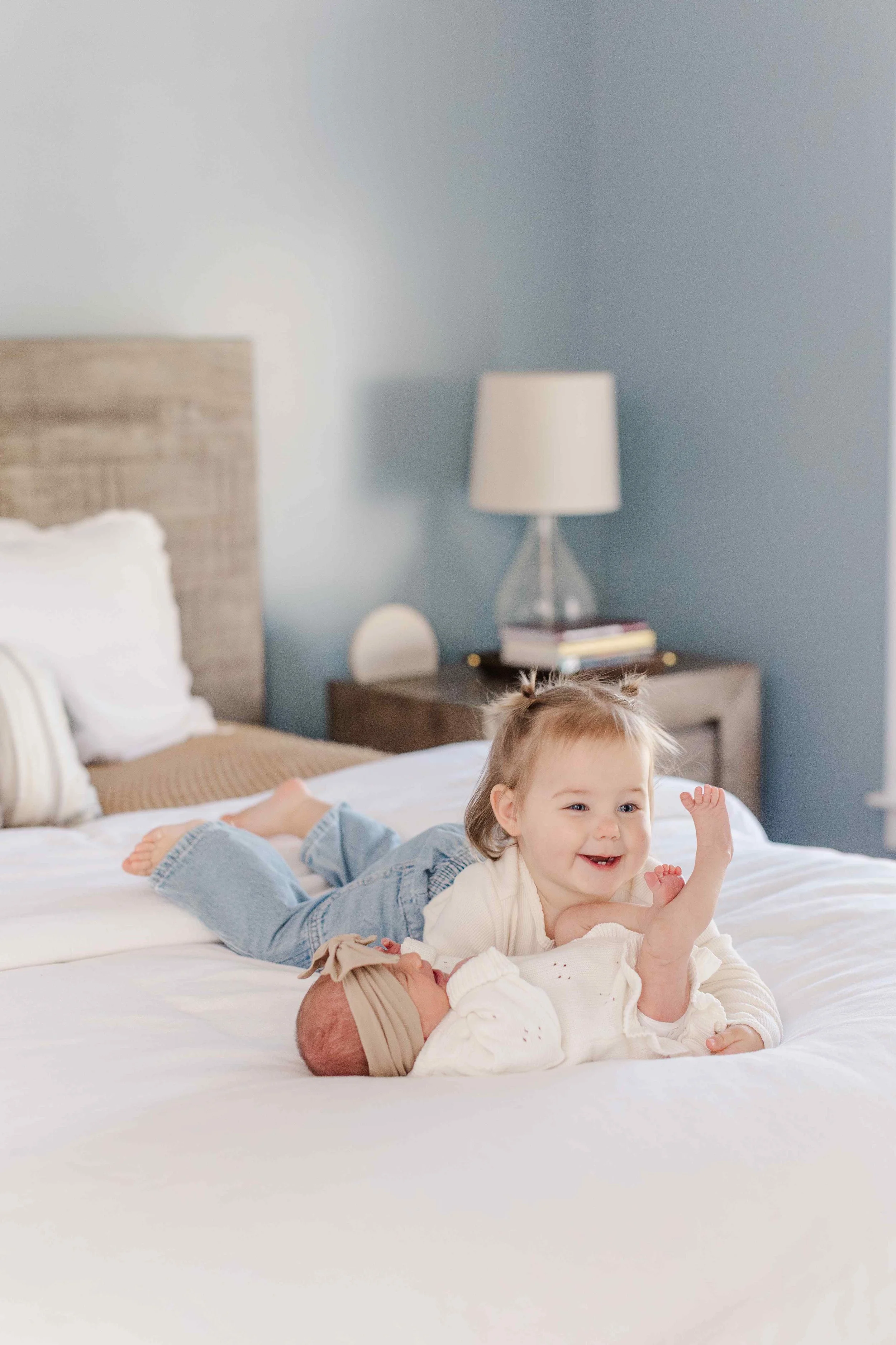 Toddler big sister next to newborn baby on bed, lifestyle newborn photographer Easley South Carolina