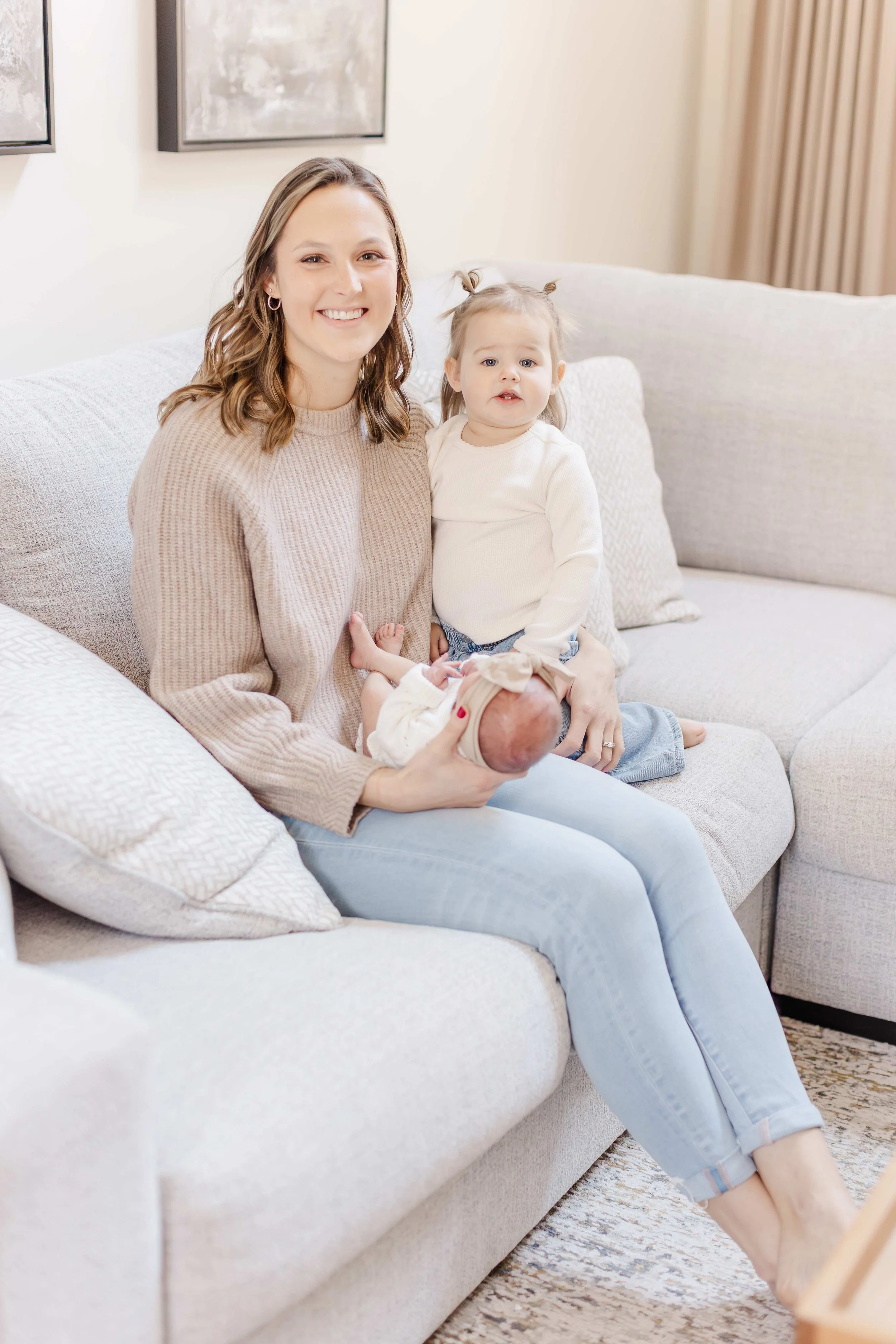 Family of four with newborn baby girl and toddler big sister on sofa, lifestyle newborn session Easley SC