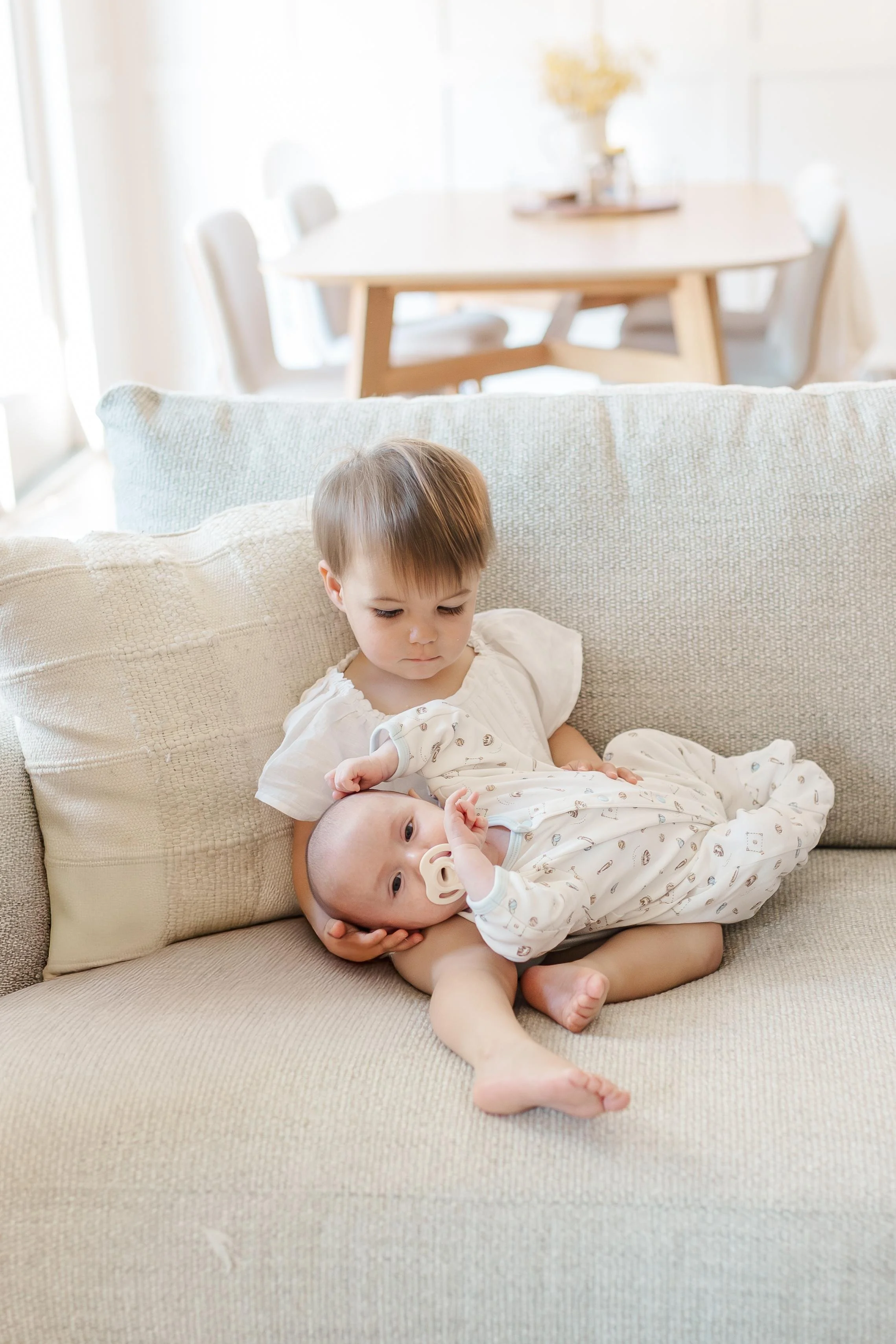 Toddler big sister holding newborn baby brother, sibling newborn photography Greenville SC