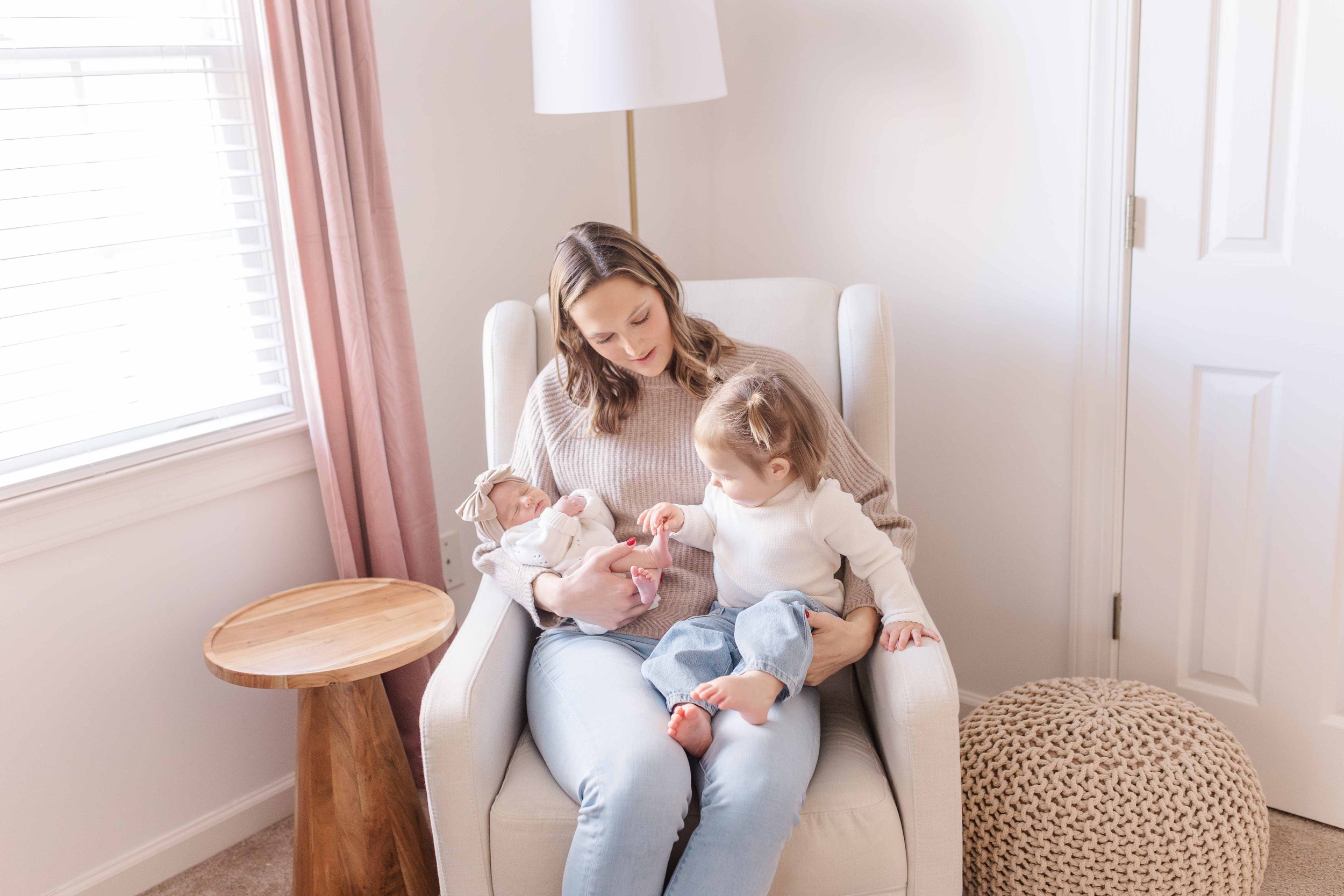 Mom holding newborn baby girl in nursery chair, Easley SC newborn photographer