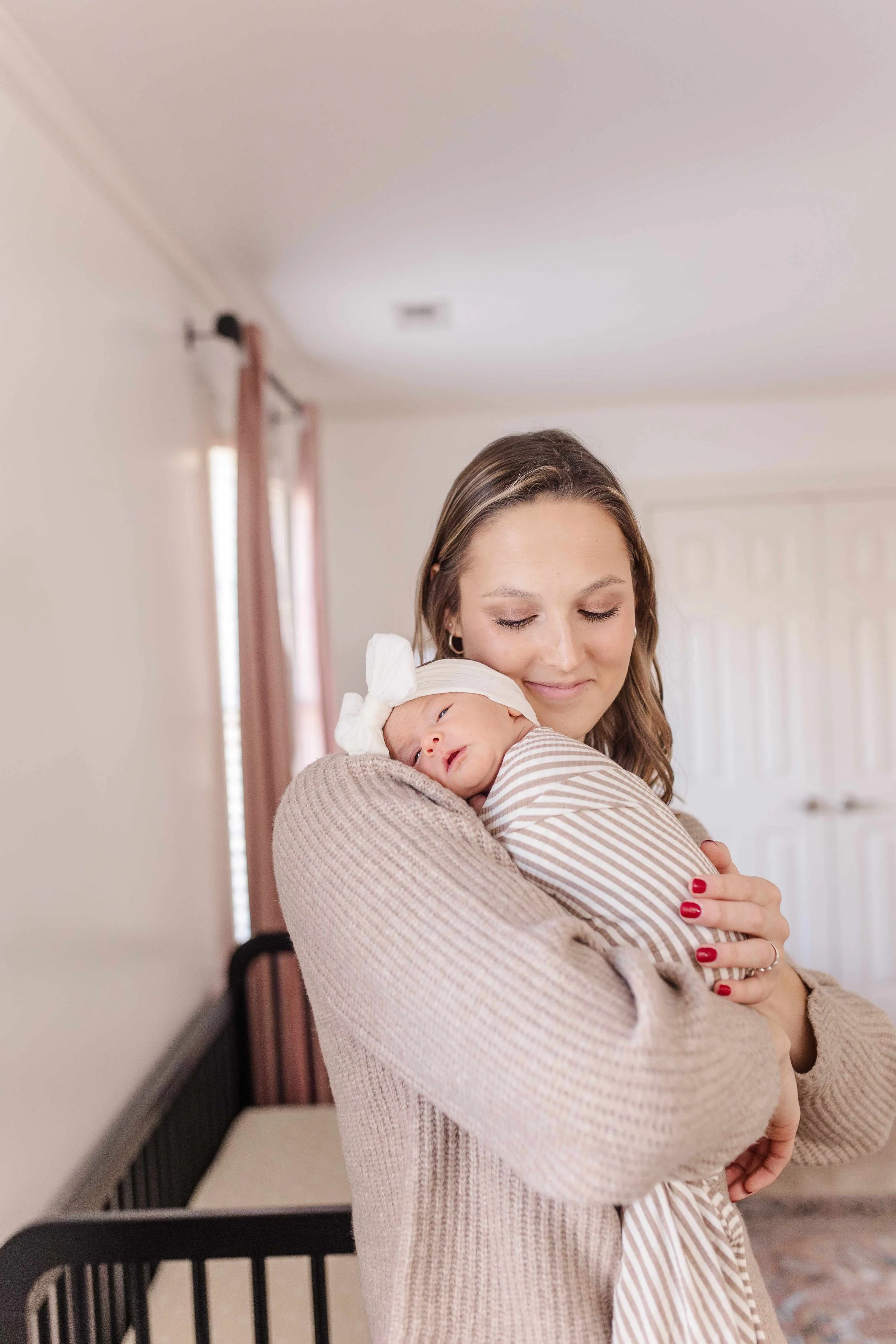 Mom holding newborn baby girl in nursery, lifestyle newborn photographer Easley SC