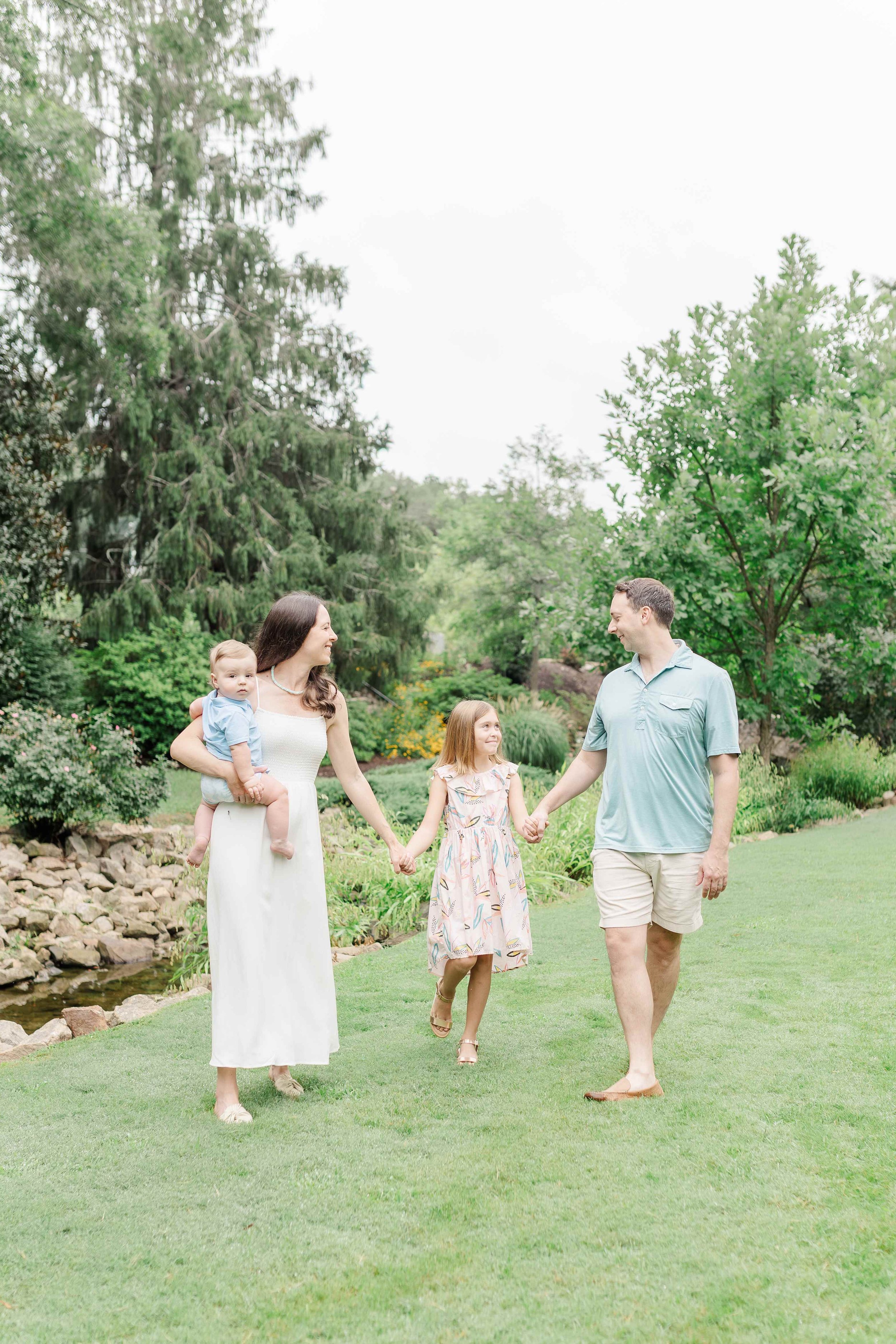 family of four walking in a park in greenville south carolina during family session with erin turner photography
