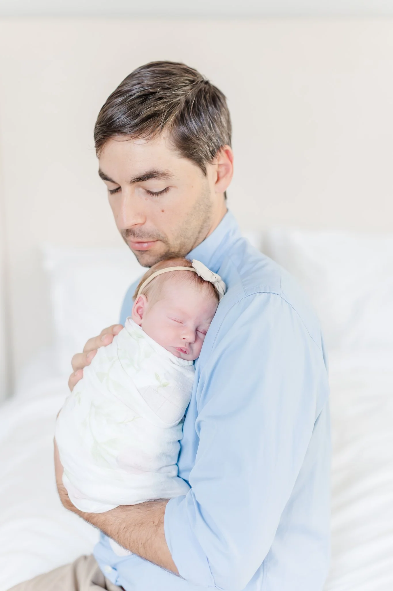 Dad in blue button-down holding newborn daughter during Powdersville SC newborn session