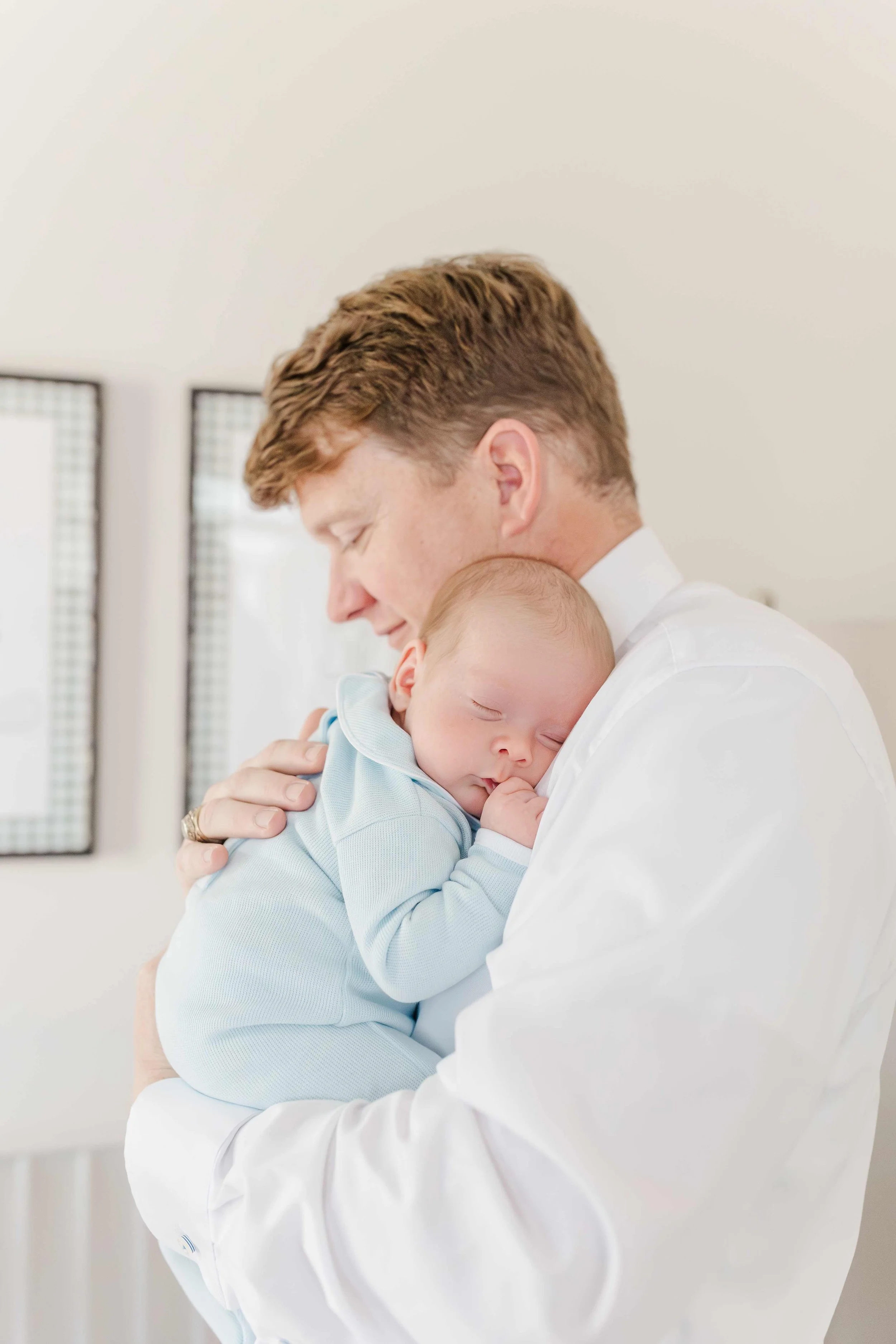 Dad holding newborn baby Thomas during in-home lifestyle newborn photography session in Laurens, SC