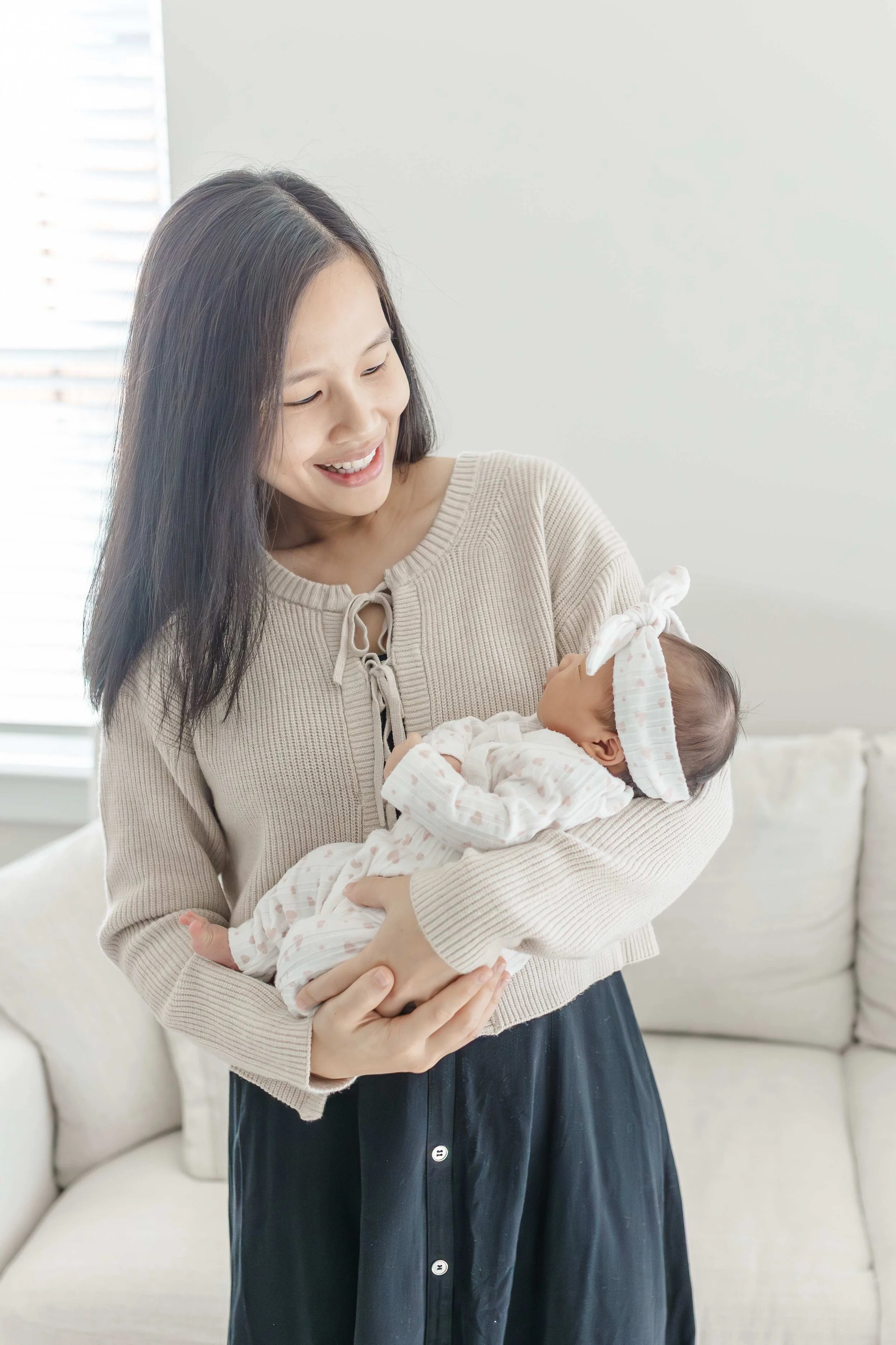 Mom cradling her newborn baby girl in her arms at home — Greenville South Carolina newborn photography
