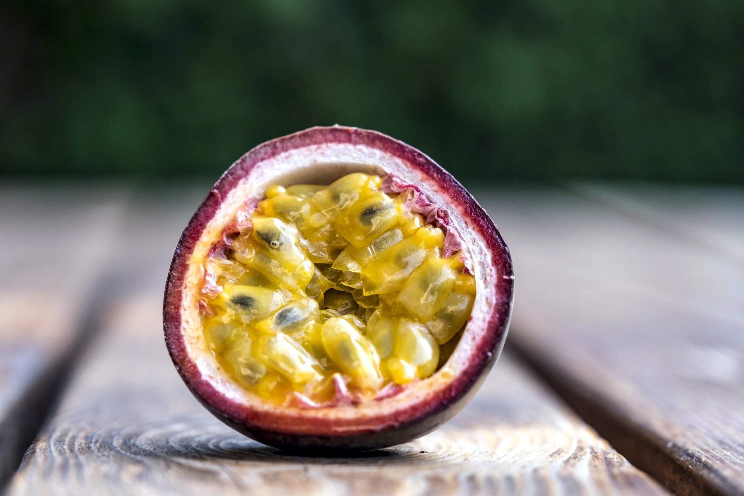 A vibrant yellow passion fruit on a wooden background: "Fresh, ripe passion fruit on a rustic wooden surface