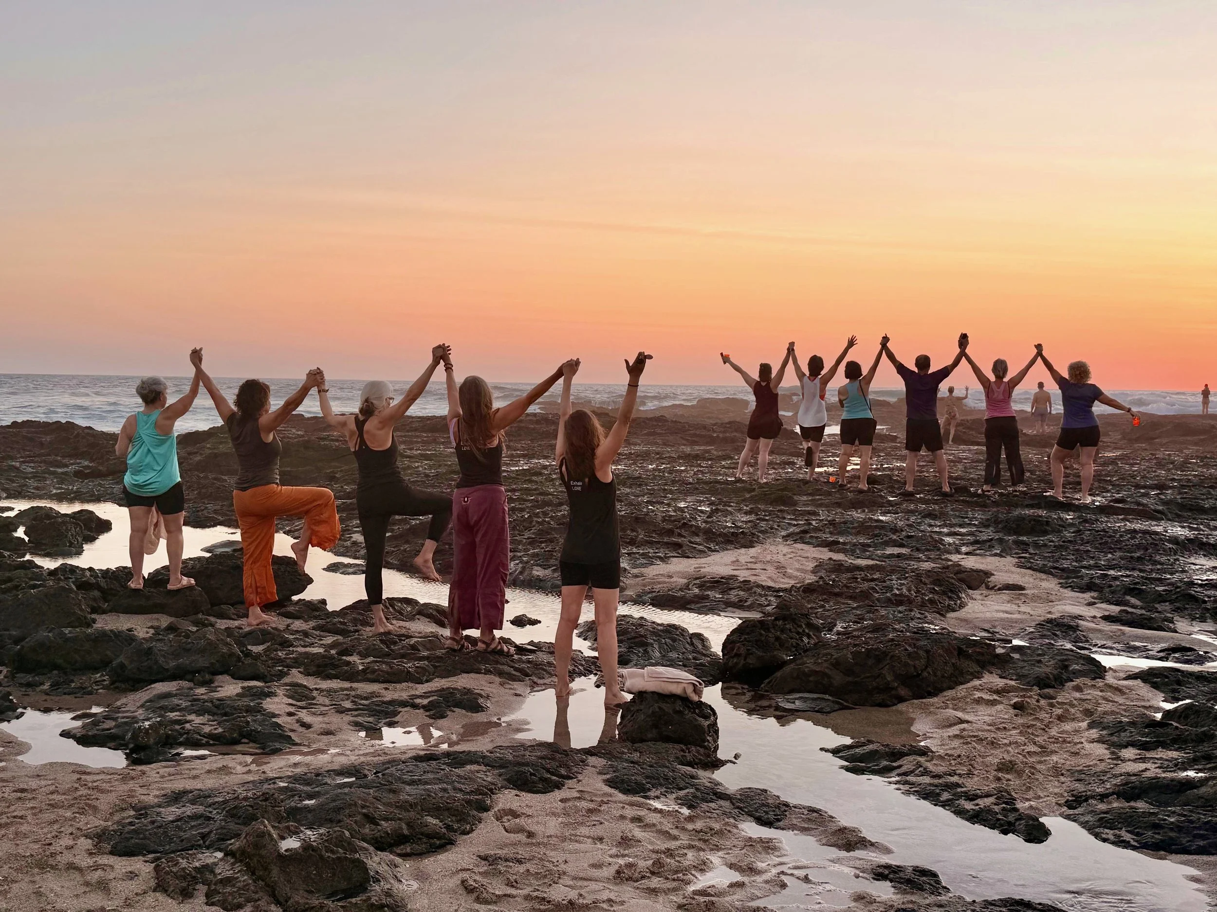 yoga group stretching on the rocks