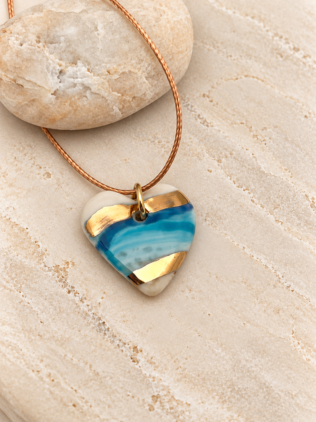 Marbled Teal Heart Pendant on Stone.png