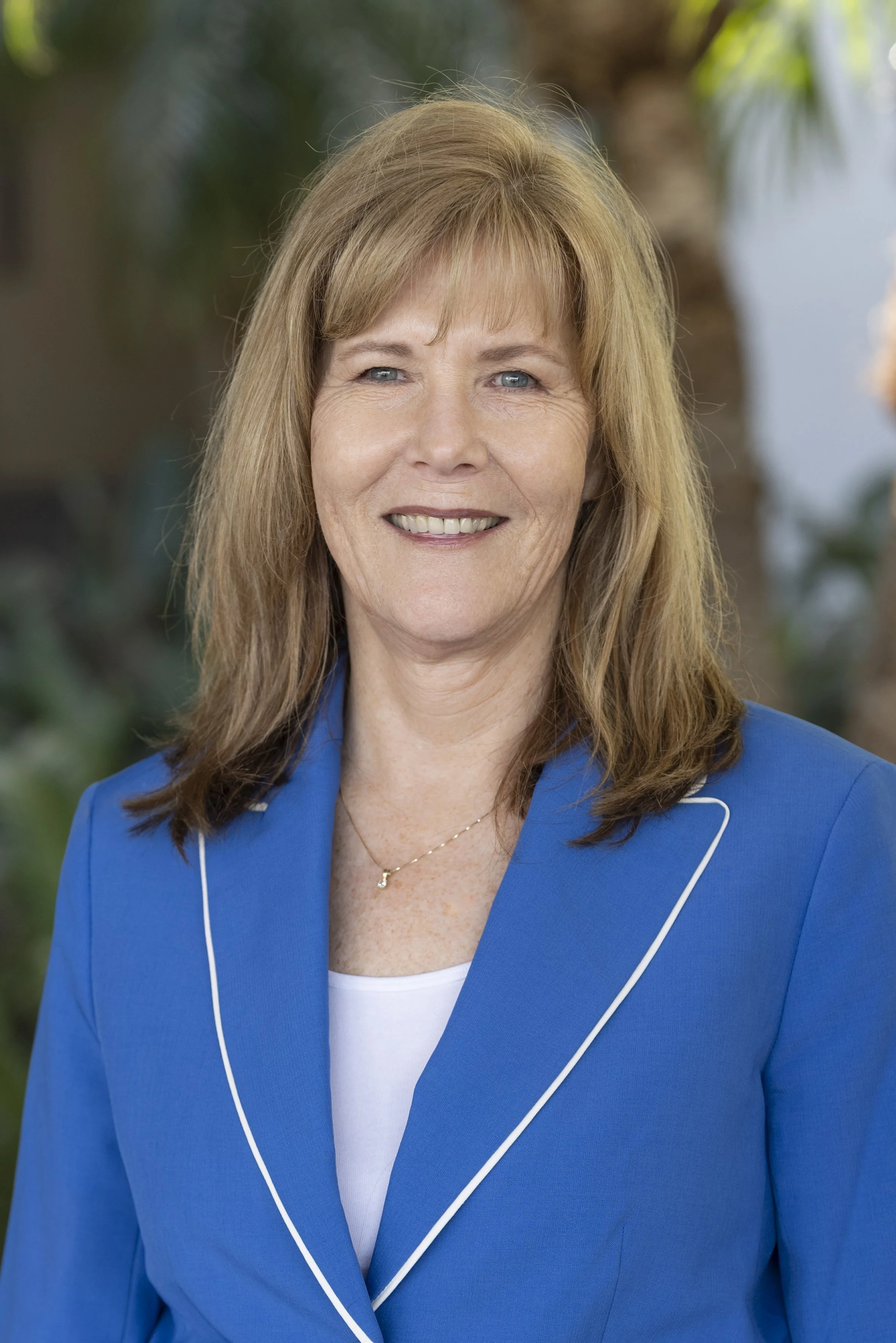 Portrait of a woman with shoulder-length hair wearing a blazer.