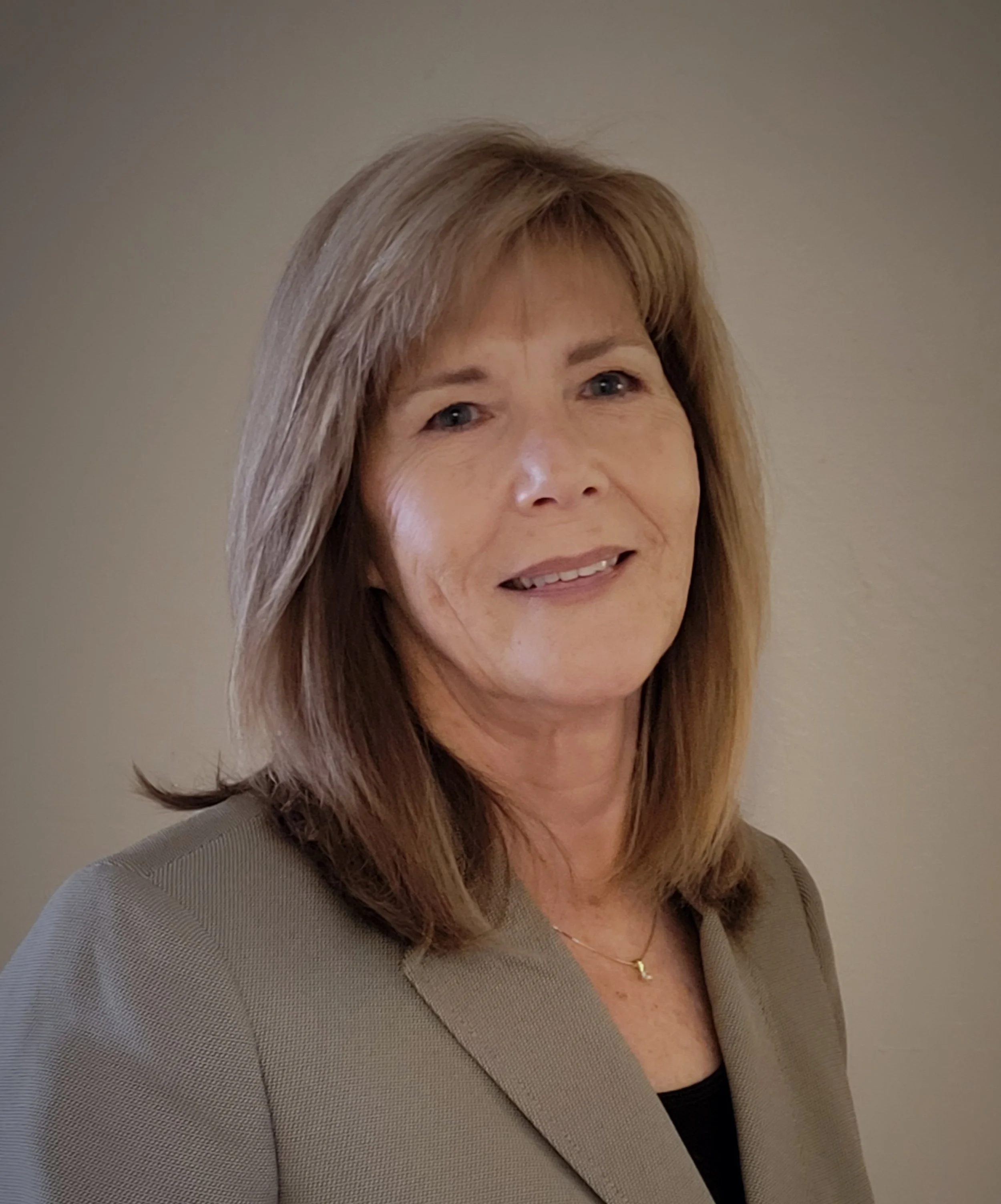 Portrait of a woman with shoulder-length hair wearing a blazer.