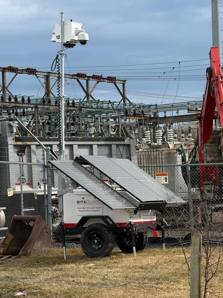 Portable solar panel system and a fence at an electrical substation.