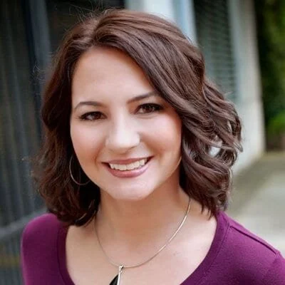 Photo of Deanna Maio with scooped neck purple top.