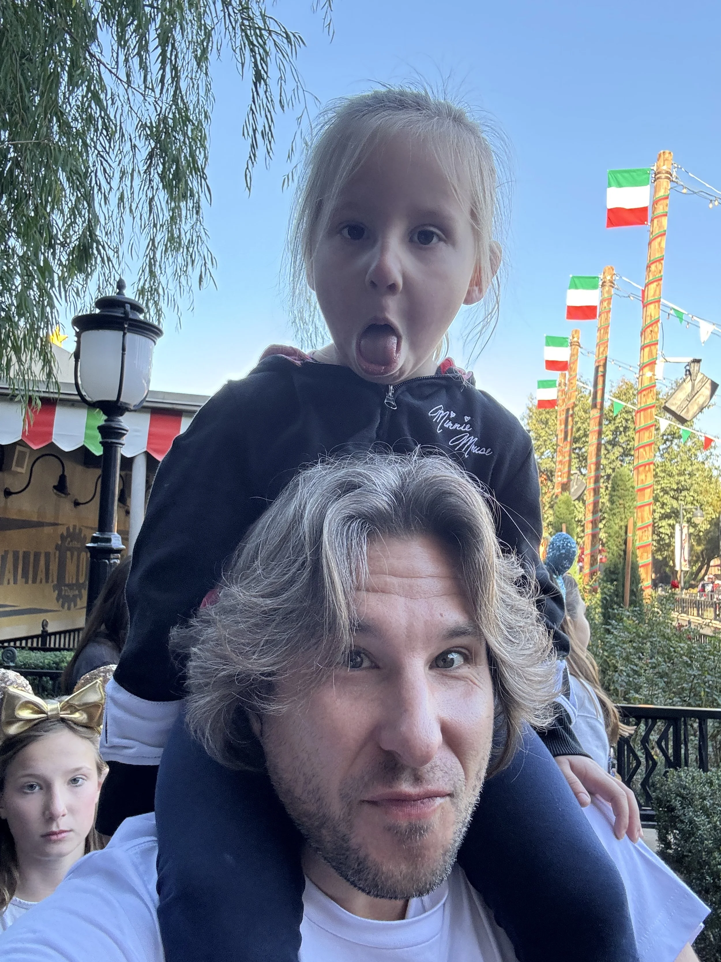 Nic Banting with toddler on shoulders making a face.