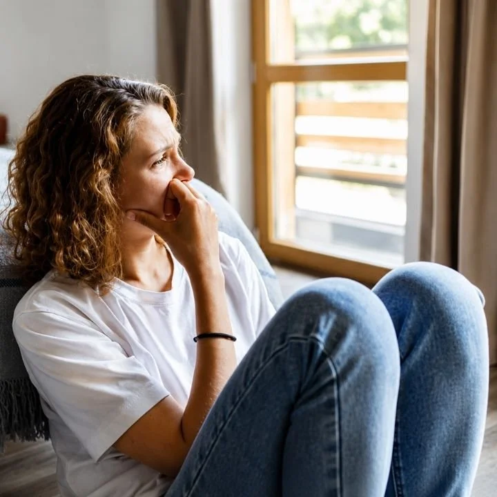Woman sitting alone feeling emotionally overwhelmed after repeatedly prioritizing others' needs.